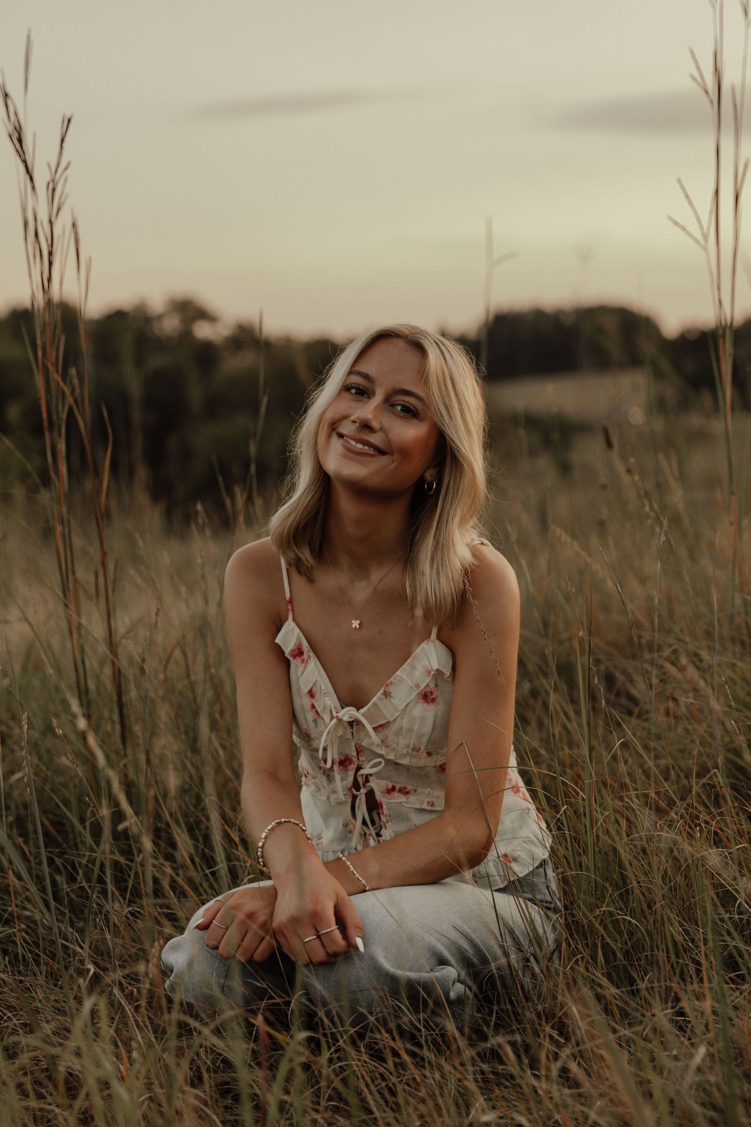 Sunset portrait in a tall grass field with warm golden lighting.