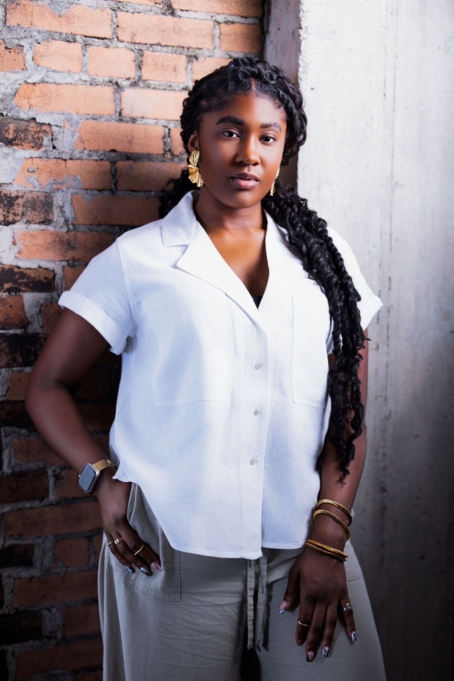 Professional portrait series against a brick wall featuring a white blouse and gray skirt outfit.