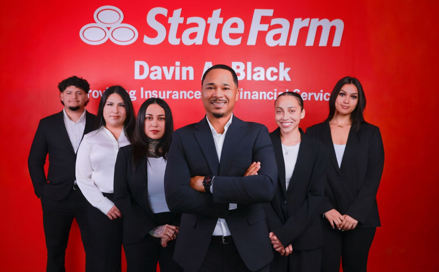 Group photo of business professionals in front of a red State Farm backdrop.