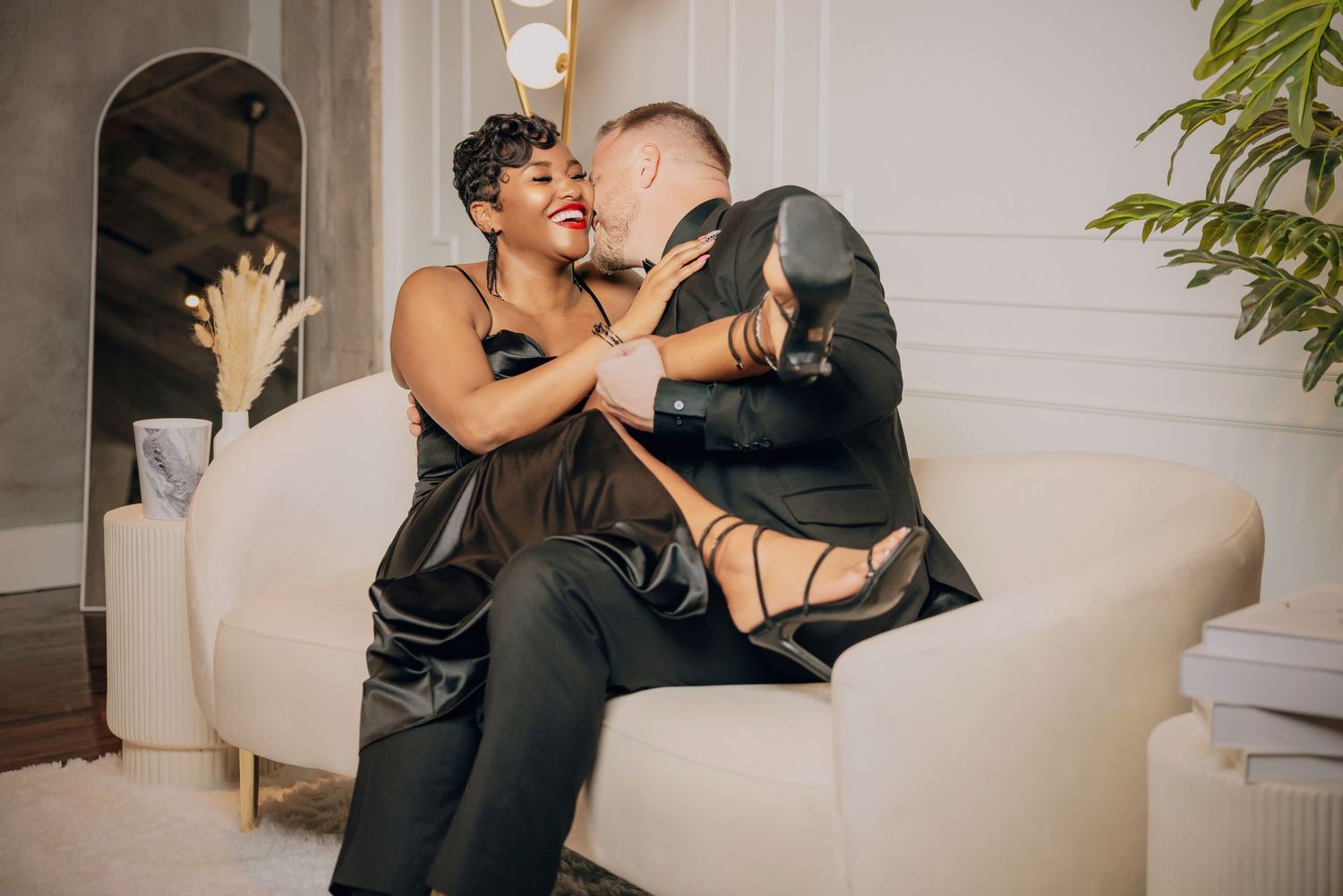 A romantic couple shares an intimate moment while dancing together in an elegantly decorated room.