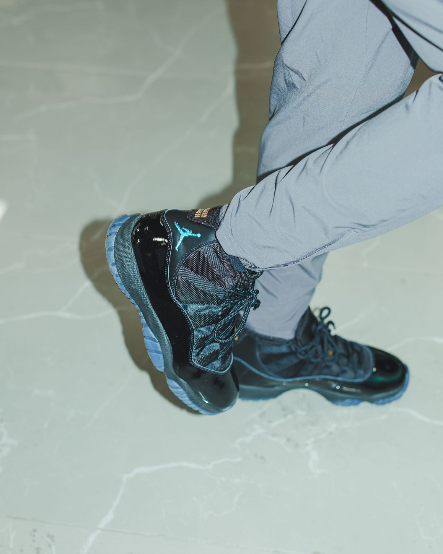 Close-up of black and blue athletic shoes on light colored floor.