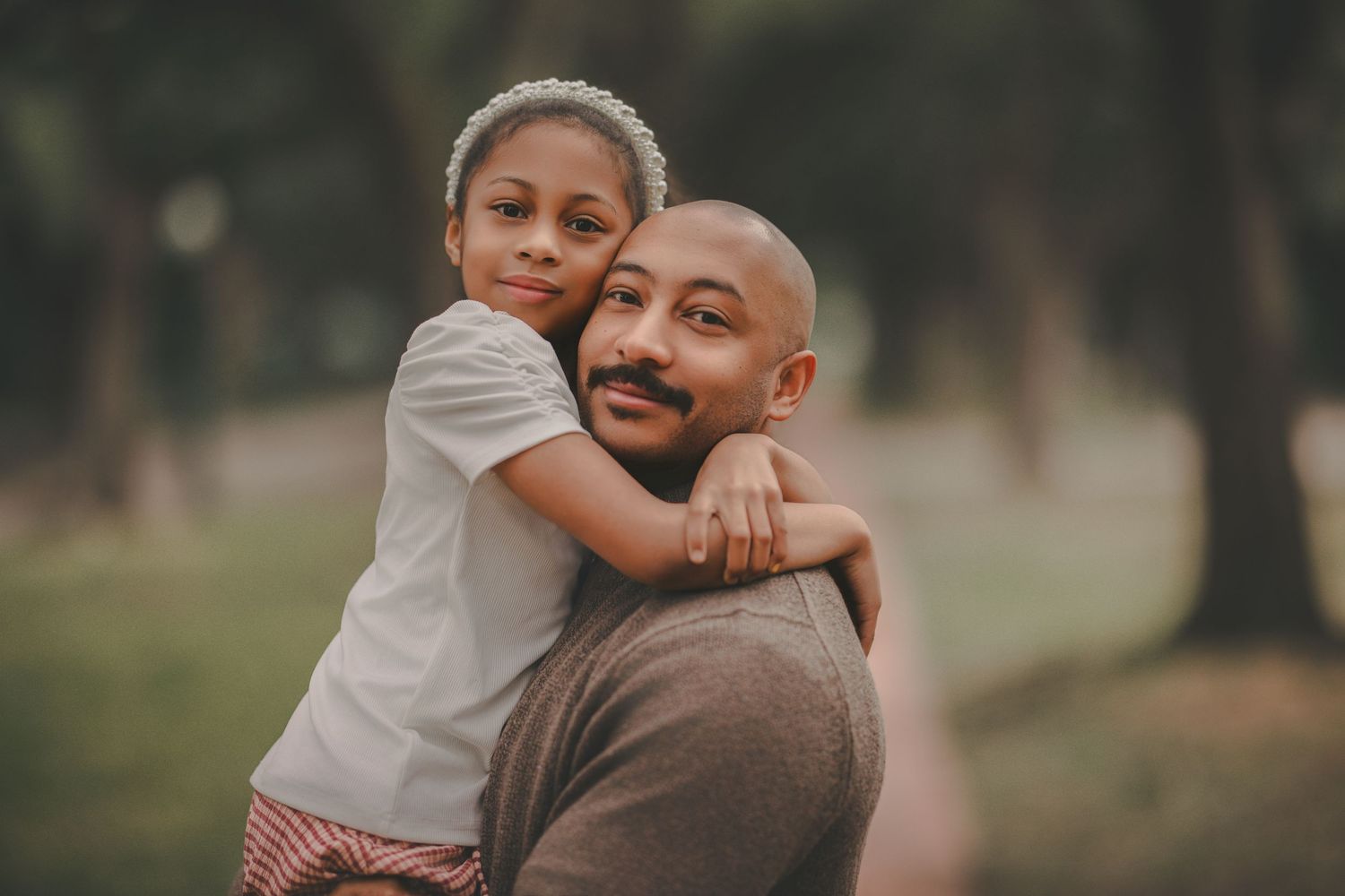 A parent and child share tender moments outdoors in a series of connected candid photographs.