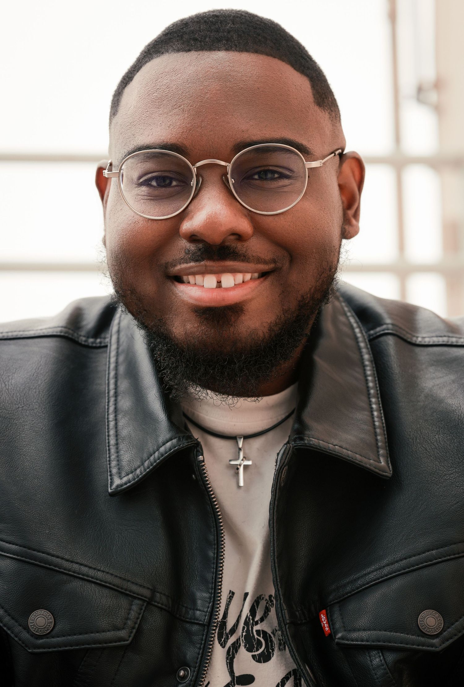 Professional headshots showing warm expressions and leather jacket against light background.