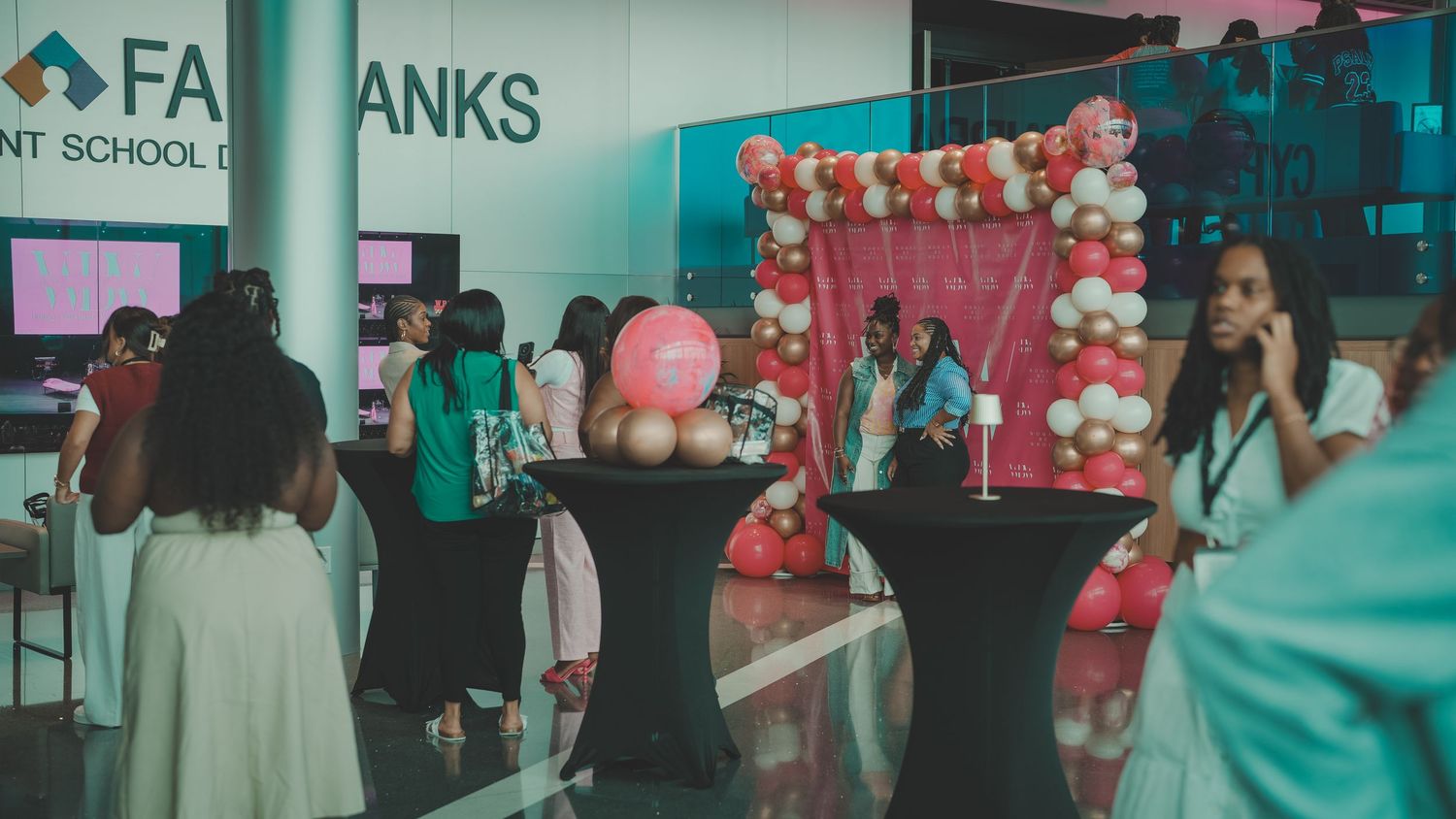 Interior of event space decorated with pink and white balloons.