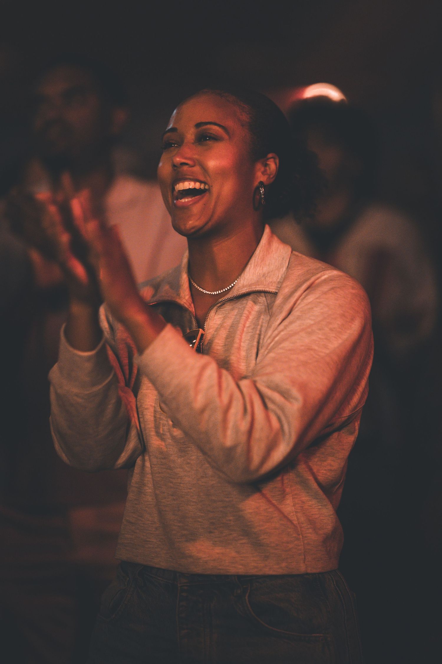 Joyful audience member laughing and clapping during a performance.