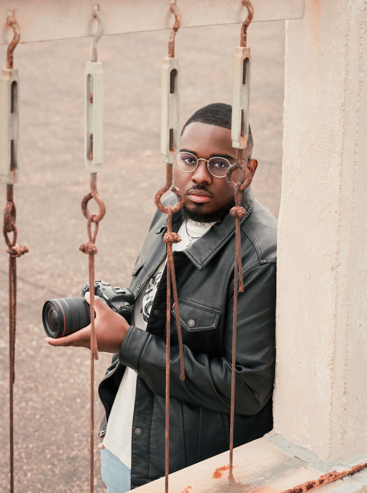 Artistic portrait through metal railings creating a unique framed perspective.