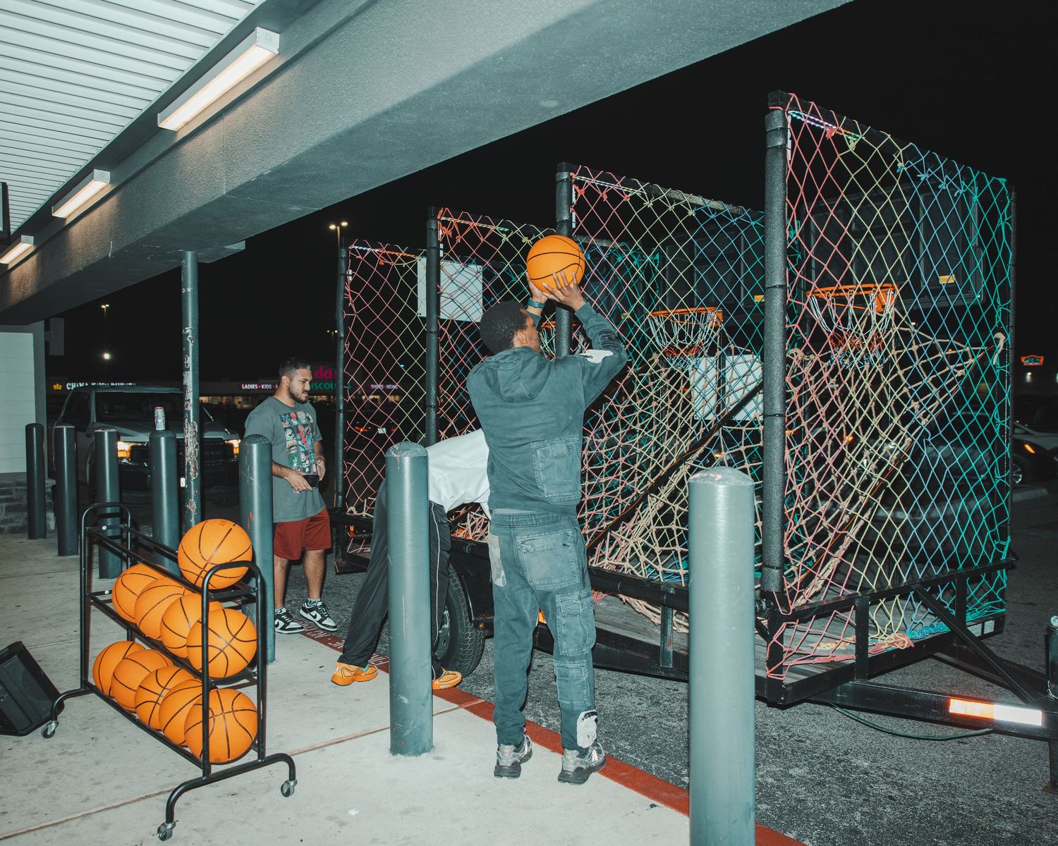 Industrial retail space with chain link fencing and orange accents in a dimly lit environment.