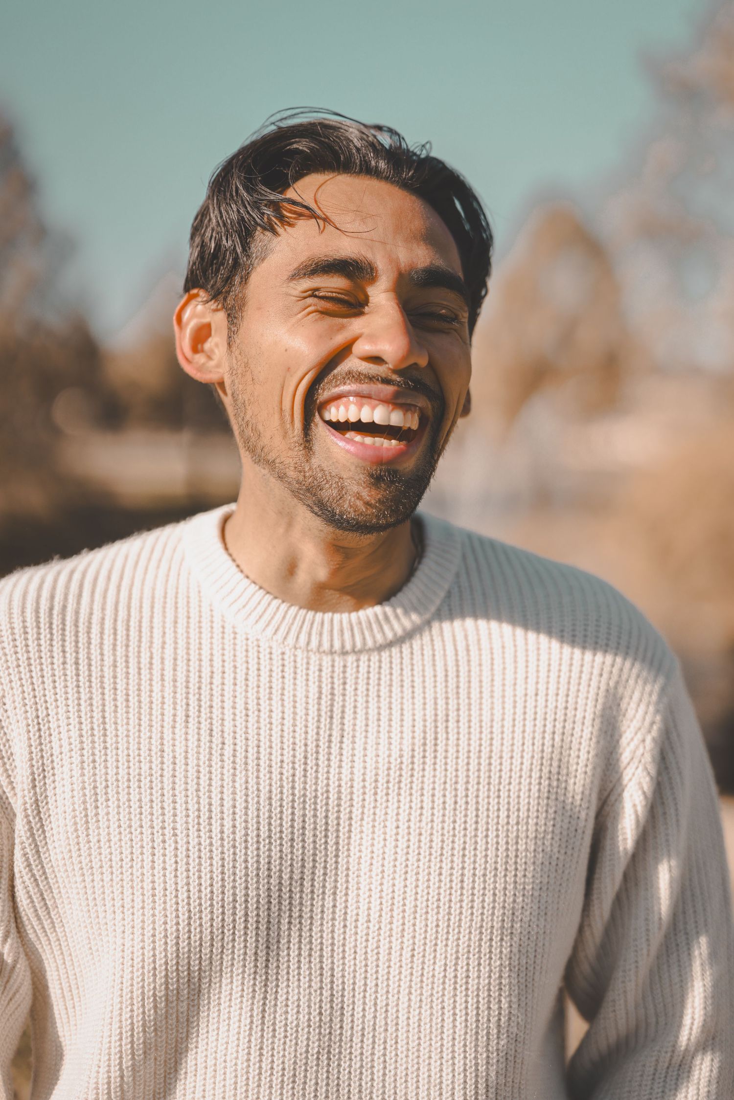 Sequence of candid shots showing joyful expressions in cream knit sweater outdoors.