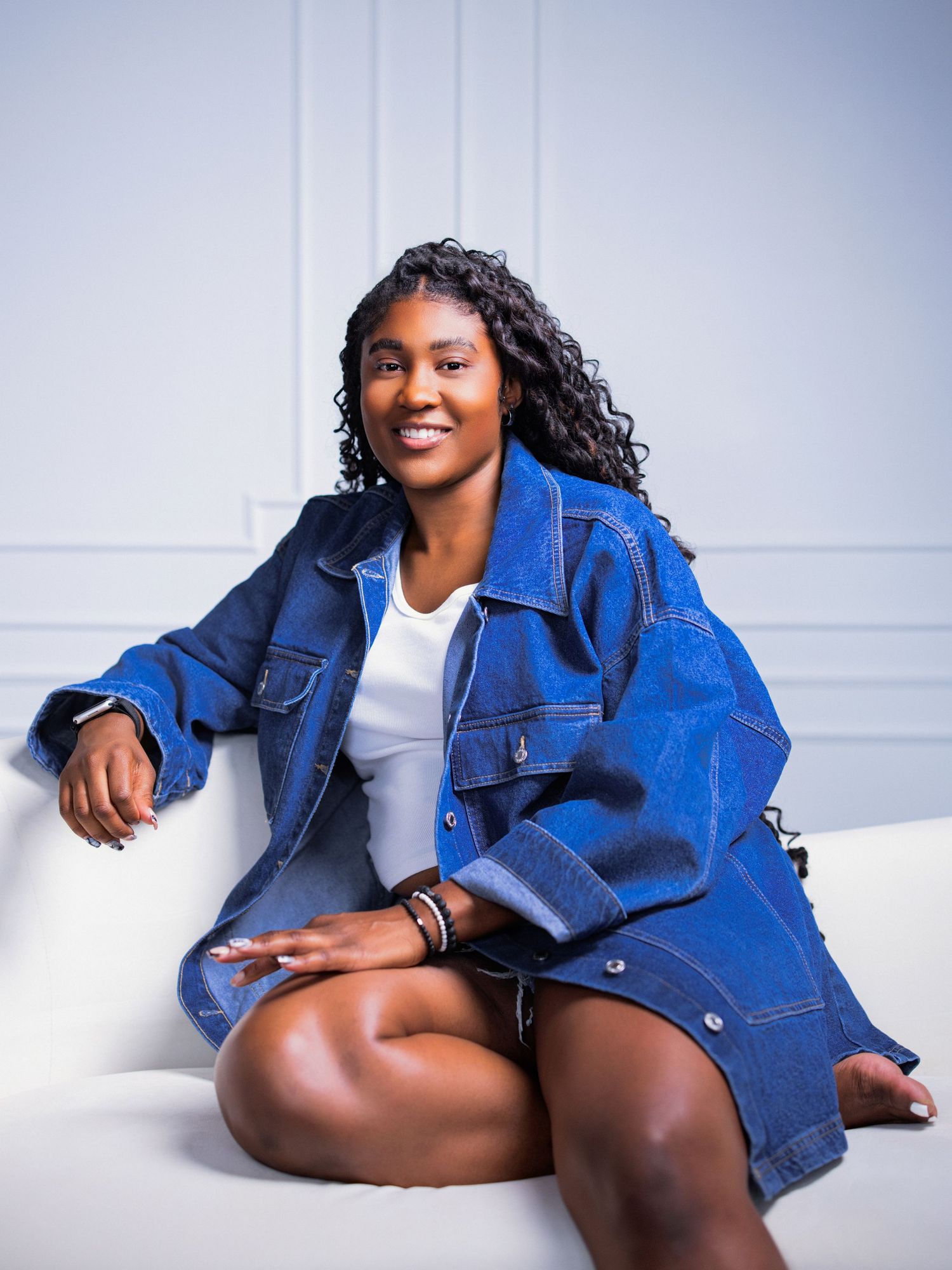 Fashion series showcasing a relaxed pose in denim jacket against white studio backdrop.
