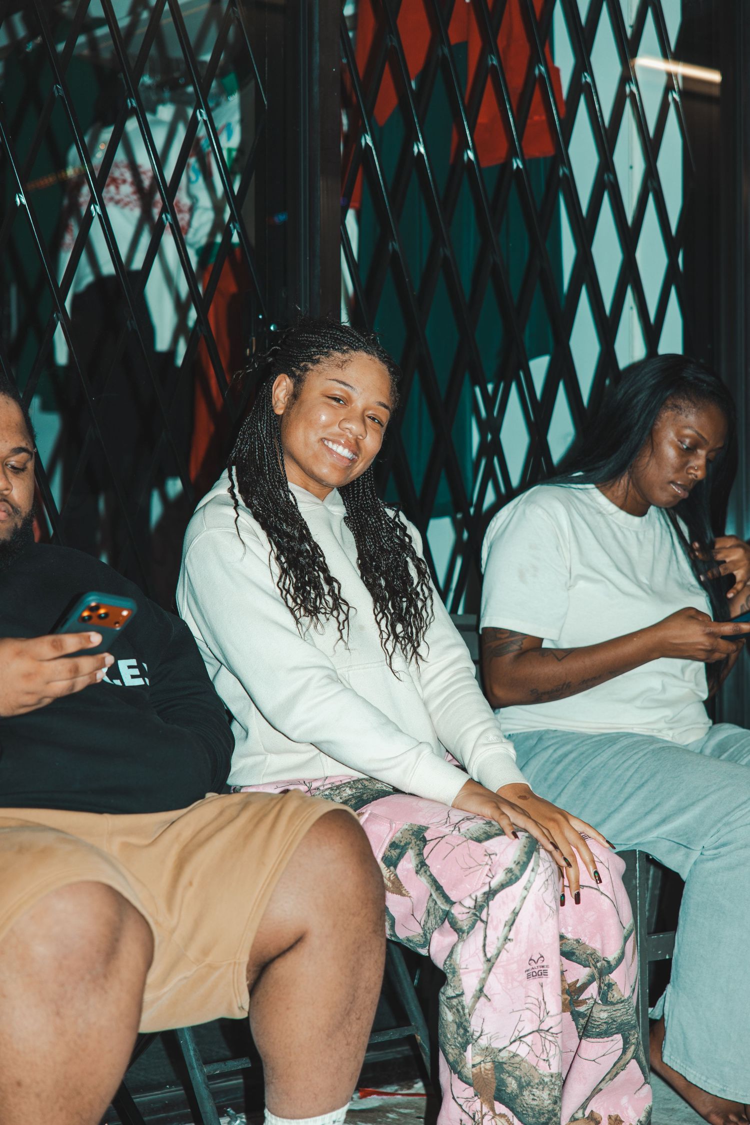 People relaxing on cushioned seating wearing casual clothes in an indoor setting.