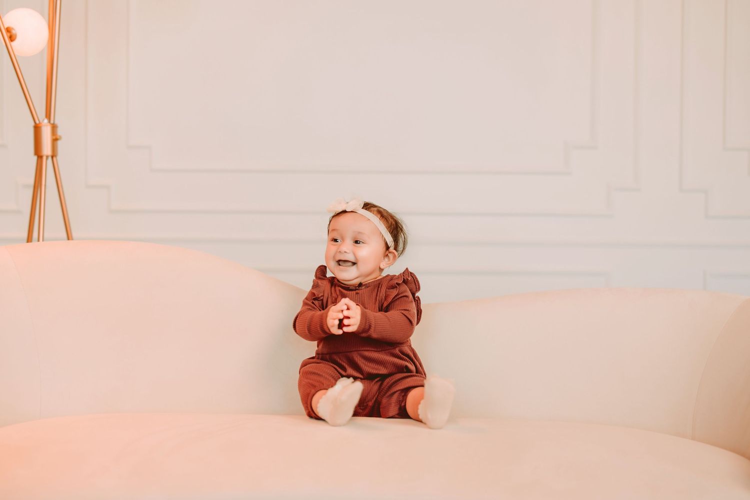 A series of four photos showing a small child playing with a teddy bear on a white bed.