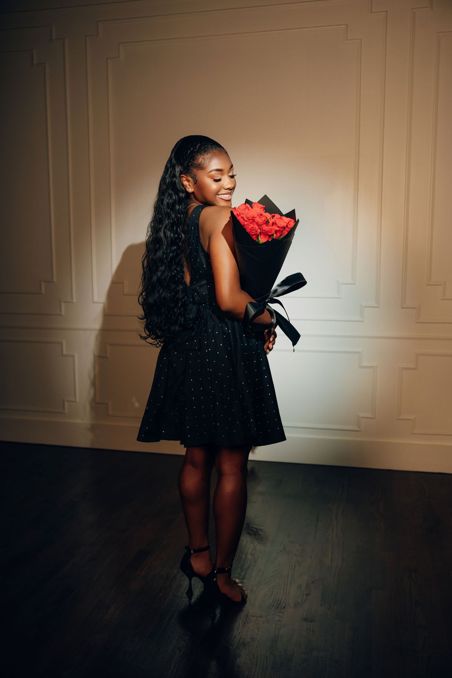 A dramatic artistic portrait series showing a person in a black dress against a white wall with moody lighting and shadows.