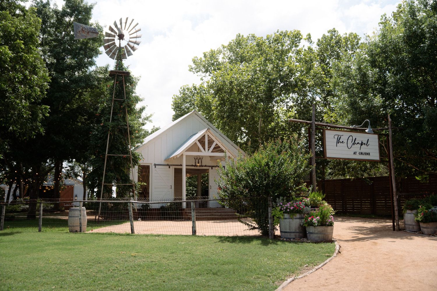 Charming white chapel wedding venue with windmill and sign at The Chapel at Hewitt. Corpus Christi Wedding Photographer