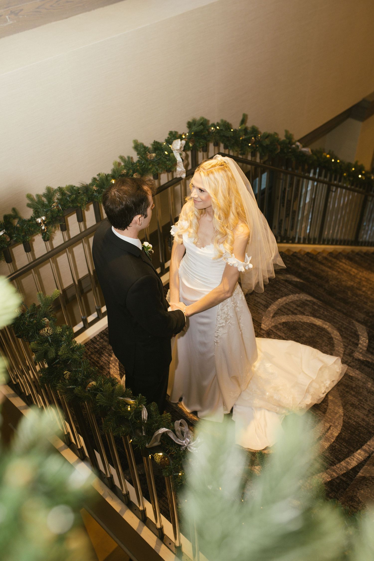Romantic wedding dance sequence captured from above on an ornate staircase with floral decorations.