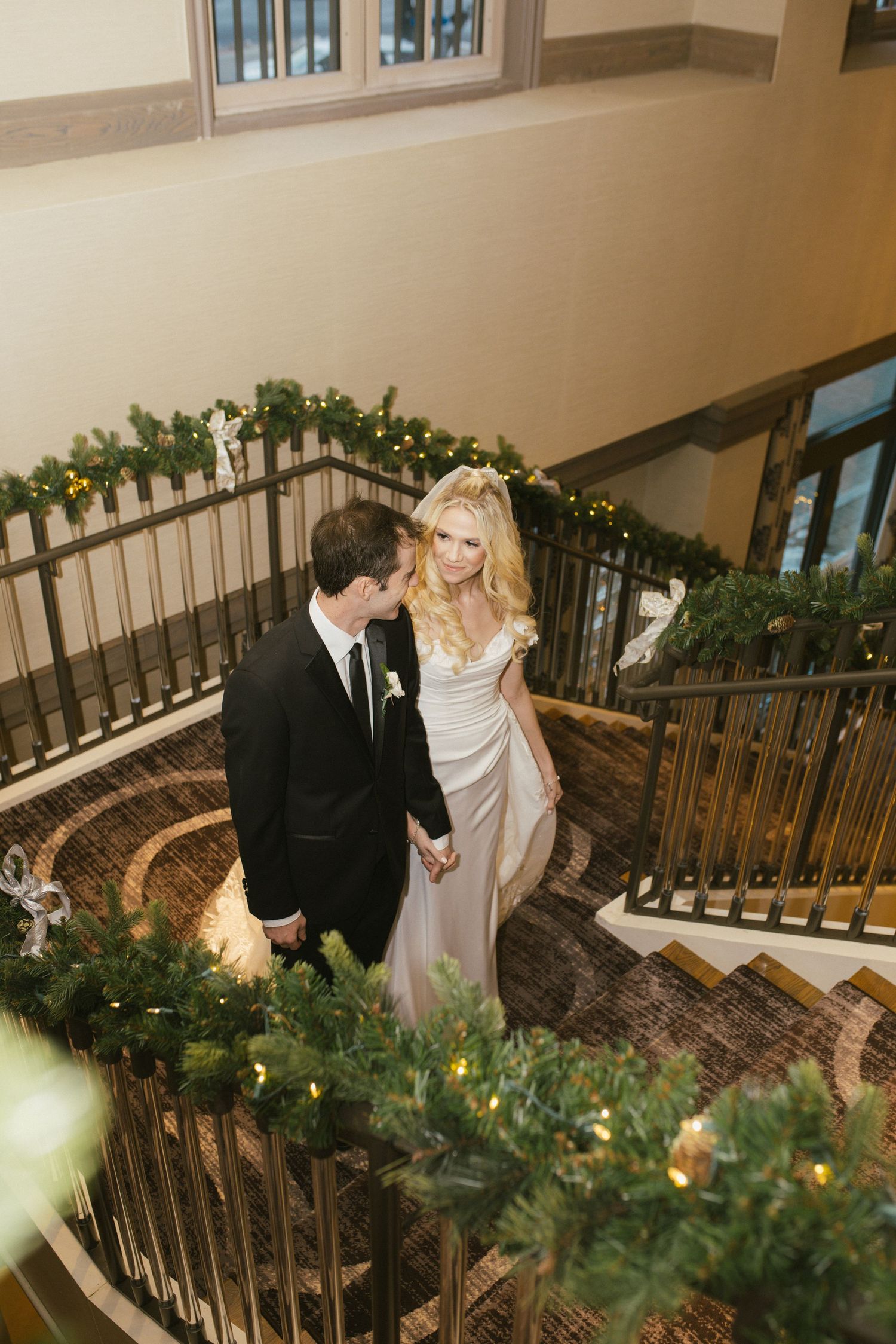 Couple sharing intimate moments on a beautifully decorated staircase with greenery.