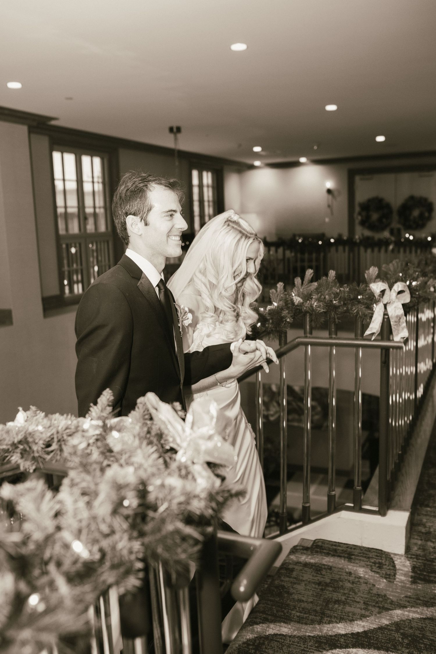 Wedding couple sharing romantic moments on an elegant staircase with ambient lighting.