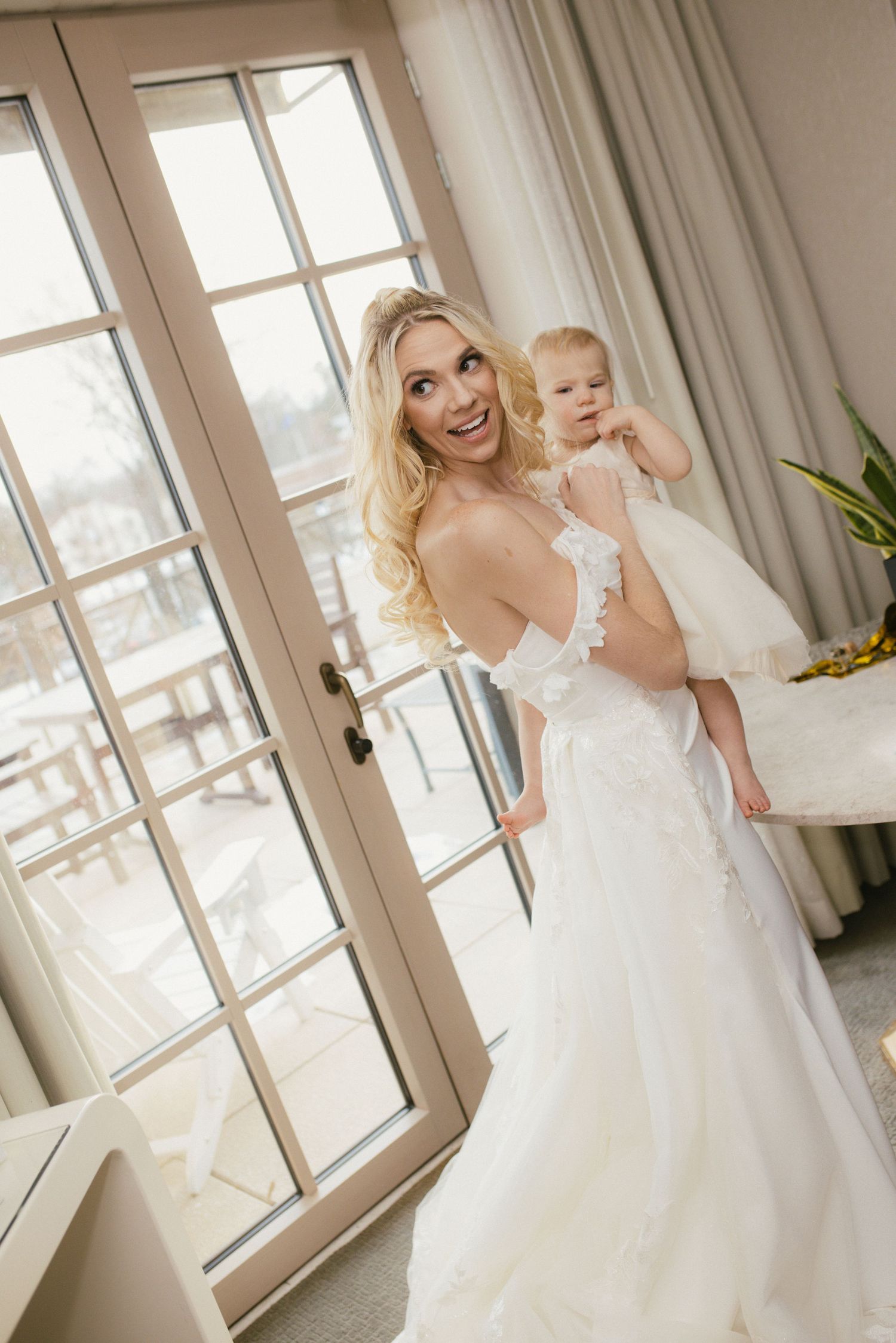 A joyful moment captured in a bright room with flowing white dresses.