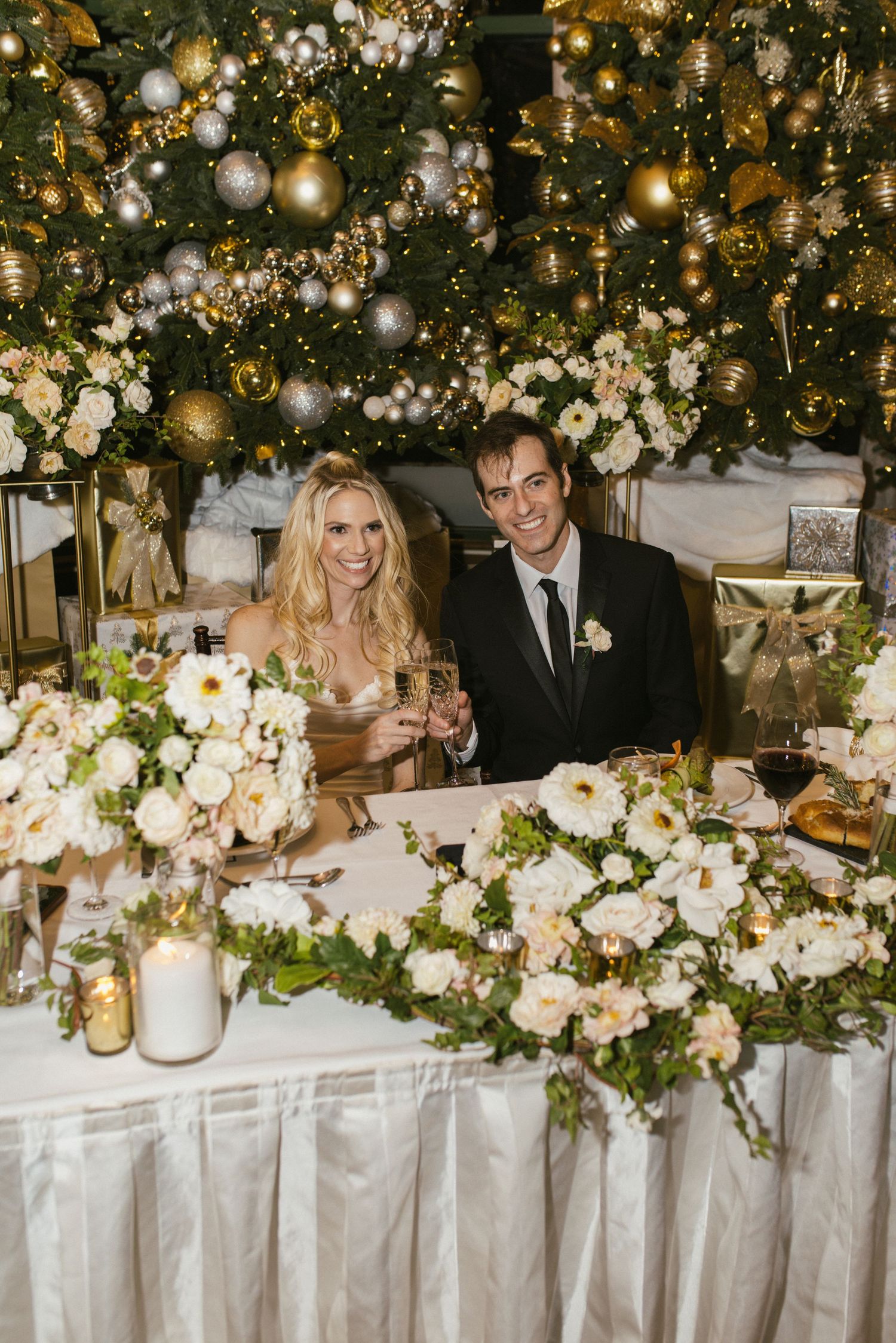 Wedding head table decorated with white flowers and gold ornaments creating a magical atmosphere.