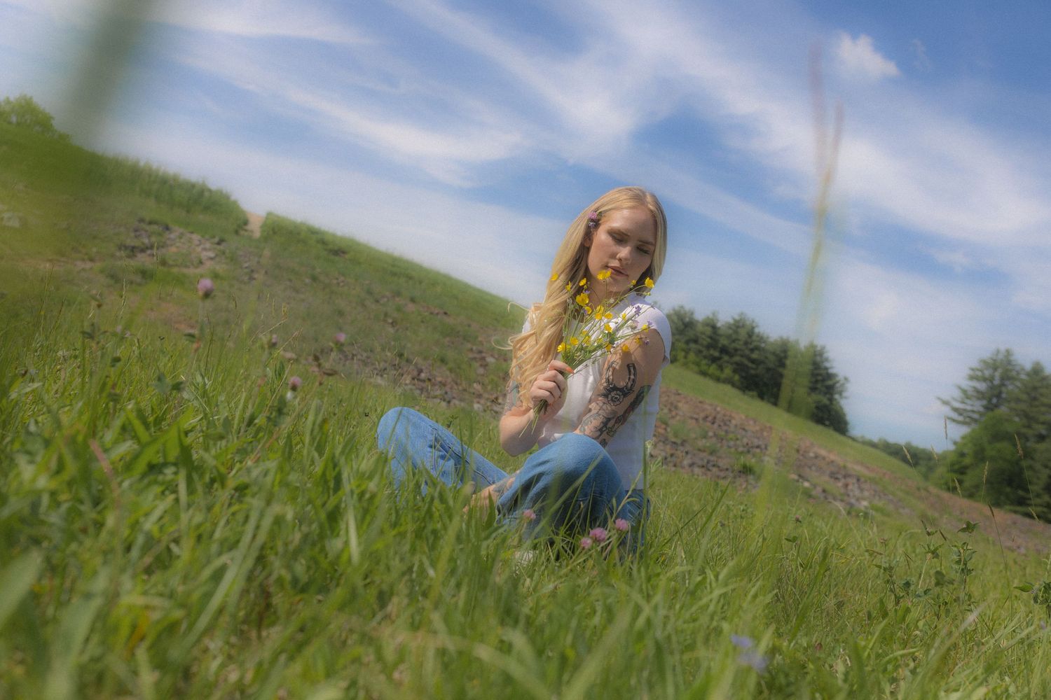 Summer photography session in a sunlit meadow with blue skies.