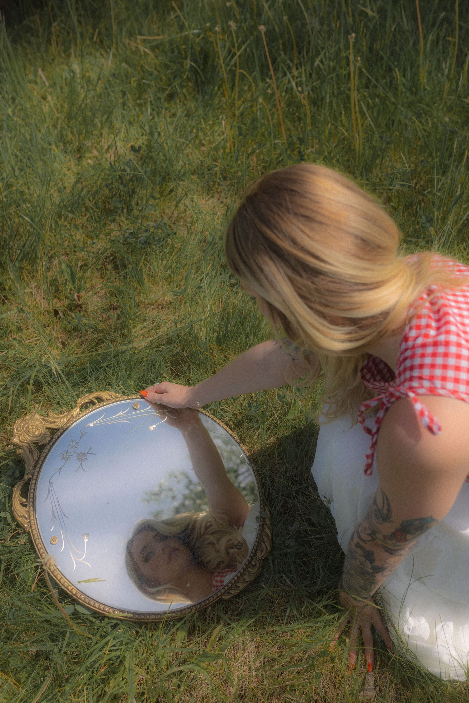 Casual fashion photography in a field wearing jeans and a white top with artistic movement.