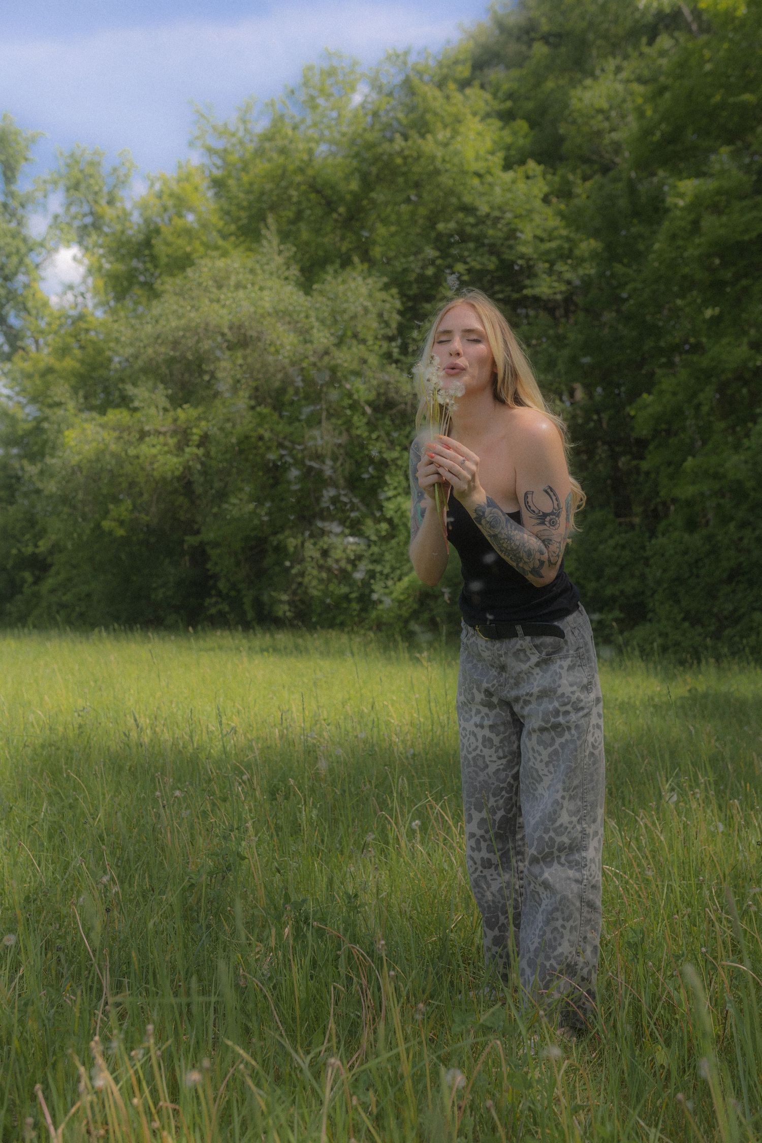 A summer fashion shoot featuring a red gingham top in a sunny meadow setting.