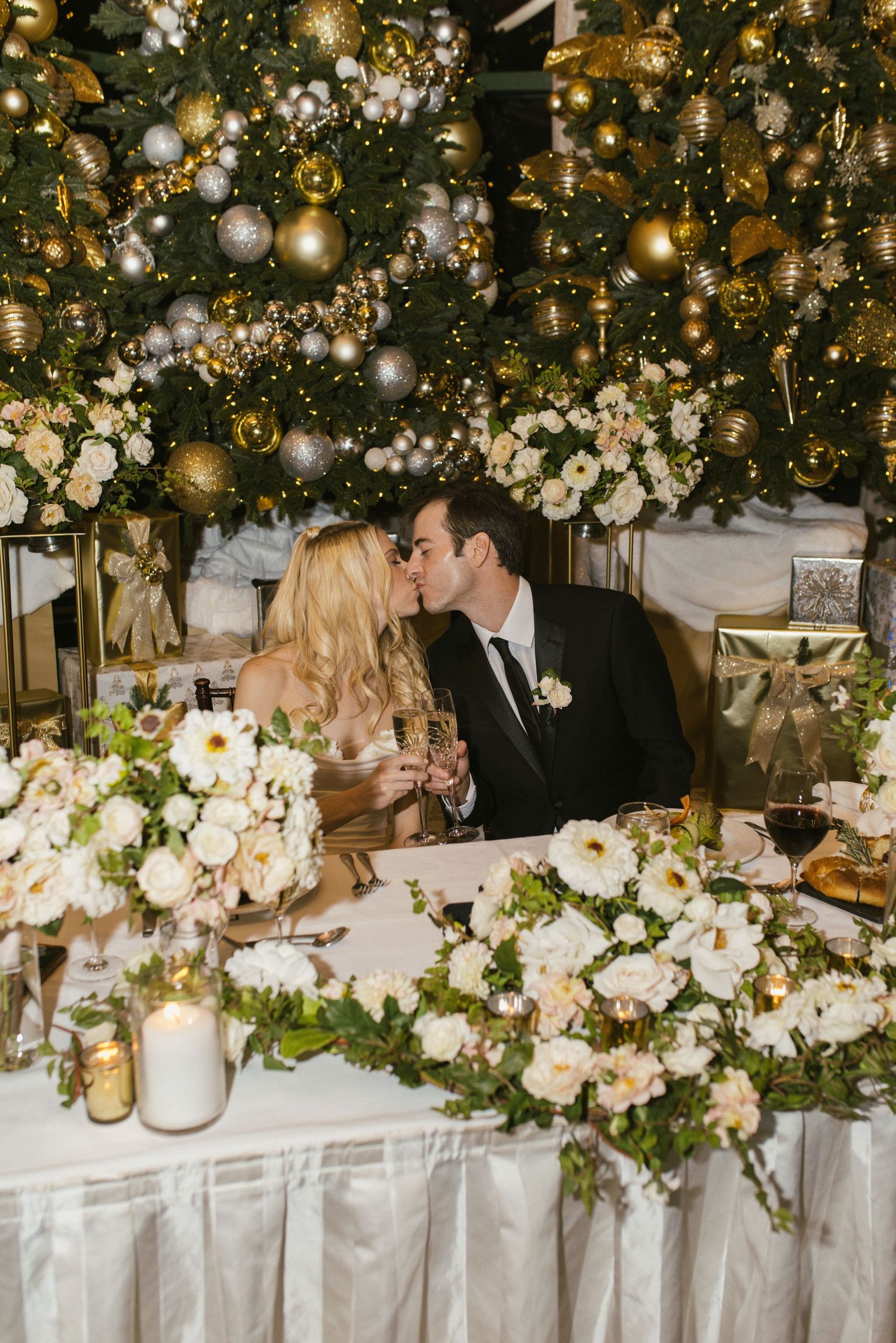 Elegant wedding reception table with white floral centerpieces and hanging lights creating a magical atmosphere.