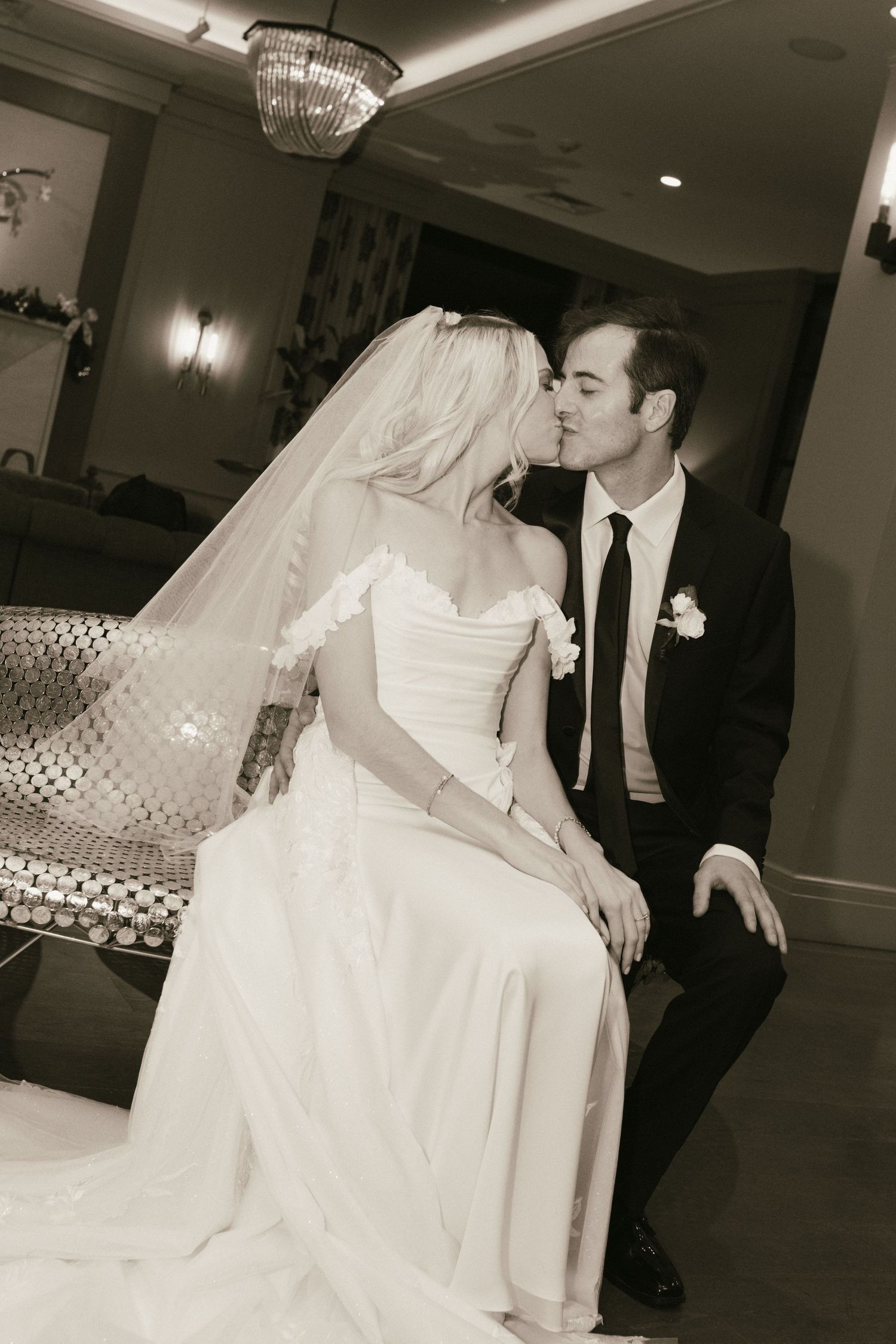 A romantic moment between newlyweds sitting together at their reception.