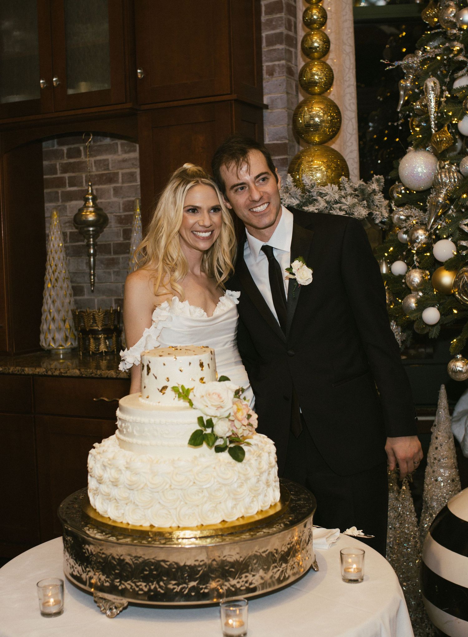 Wedding cake display with classic white tiered design on ornate gold stand.