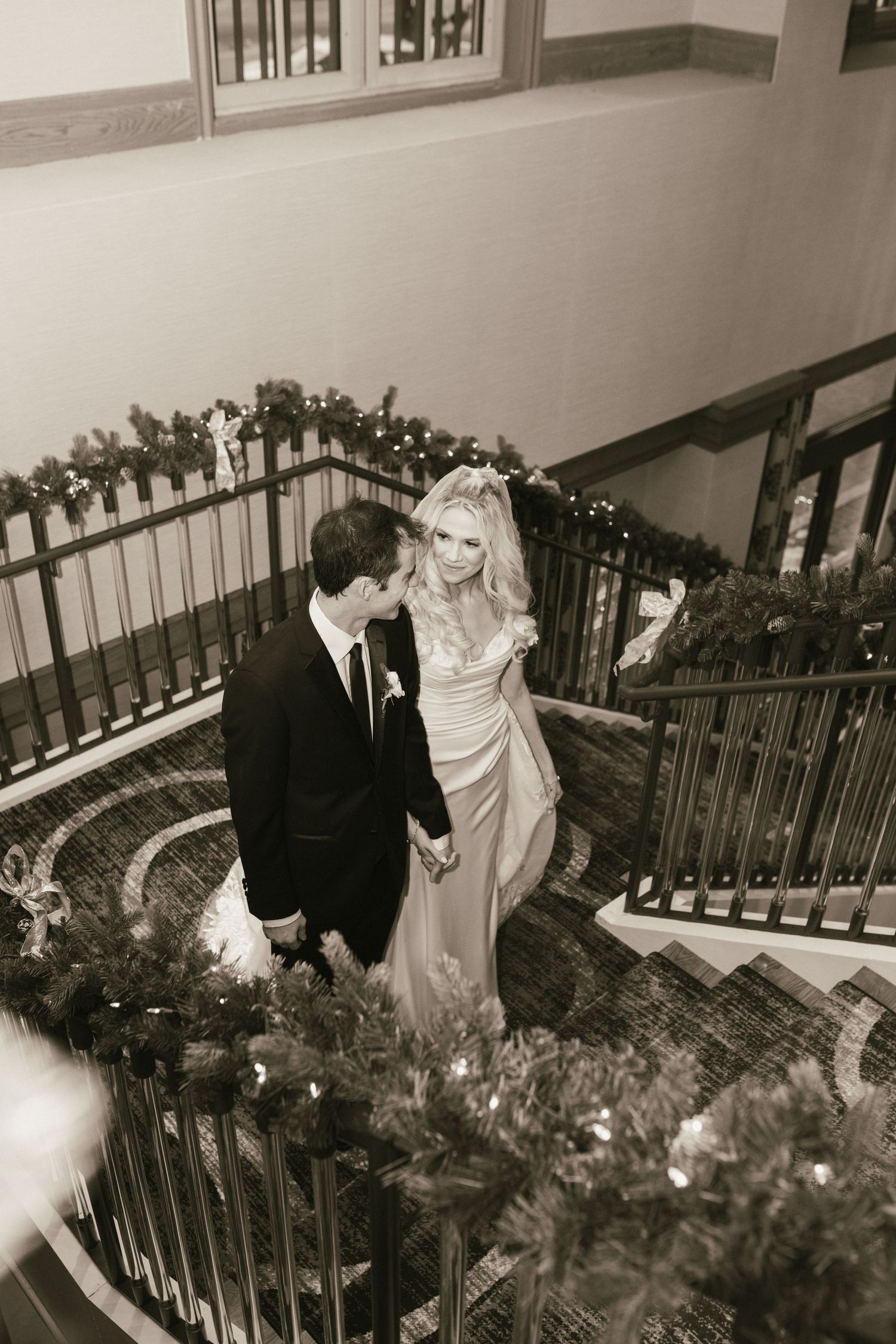 Artistic wedding photography sequence on decorated staircase with greenery.