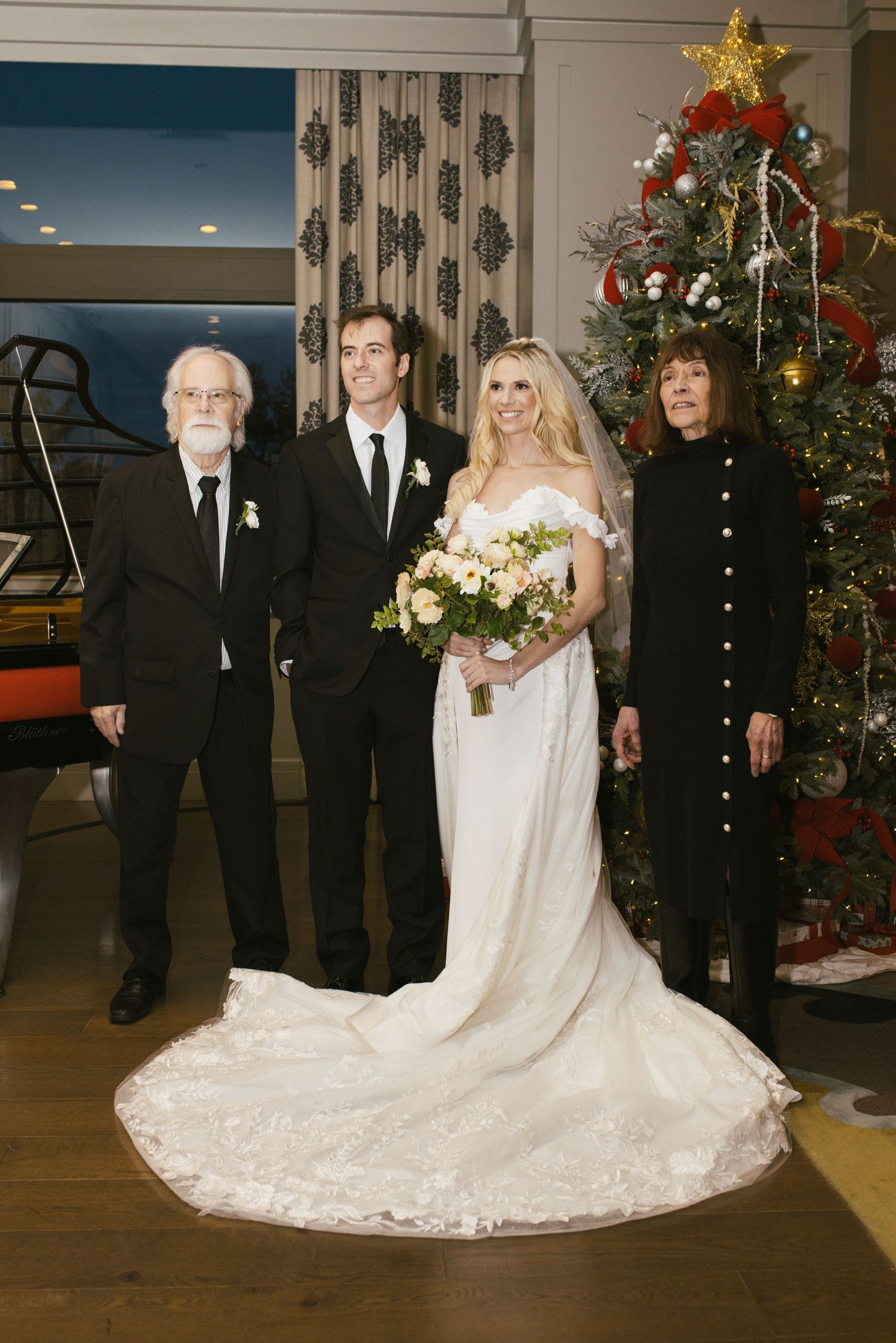 A wedding portrait with a beautifully decorated Christmas tree in the background.