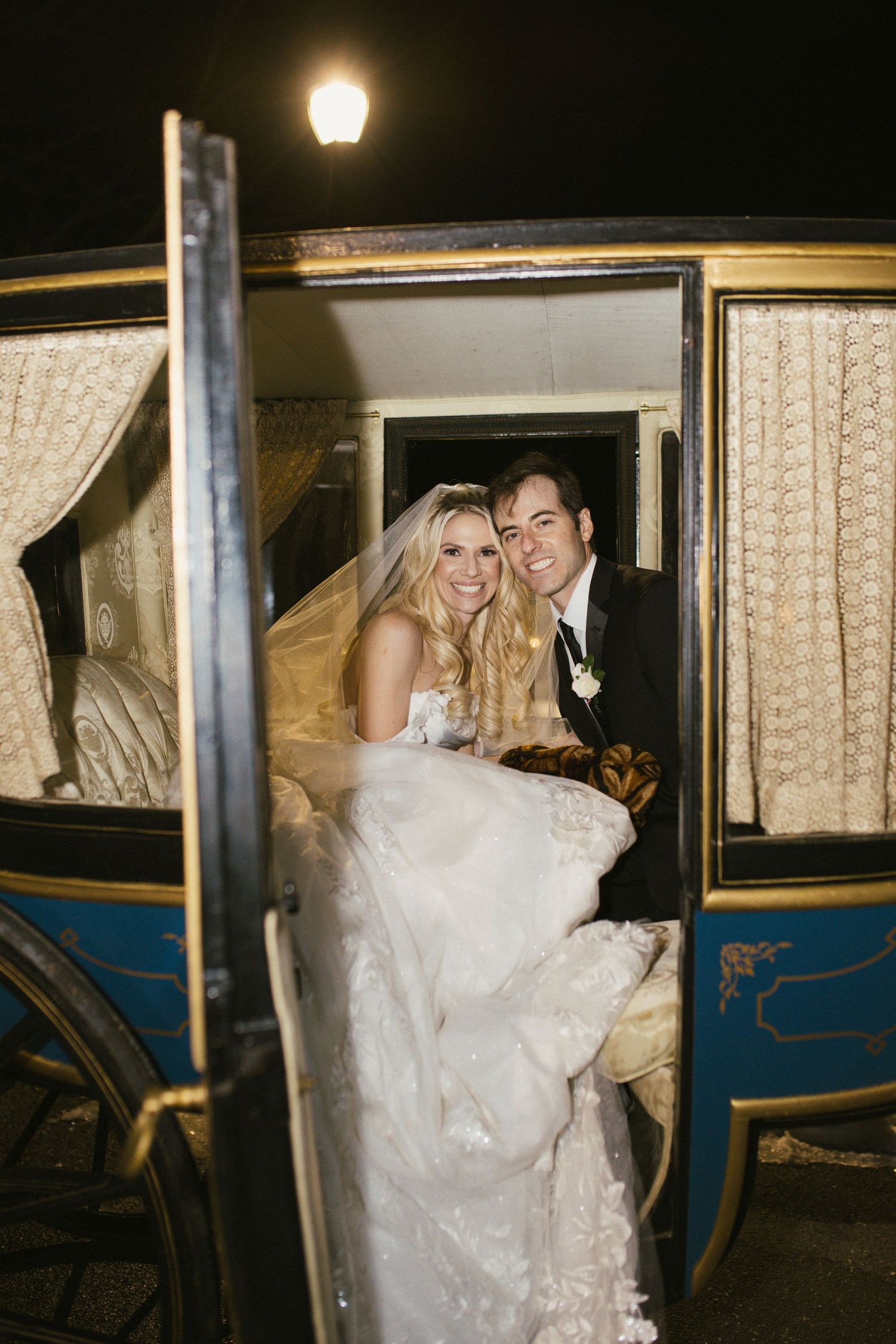 Wedding couple sharing a romantic moment inside a classic horse-drawn carriage.
