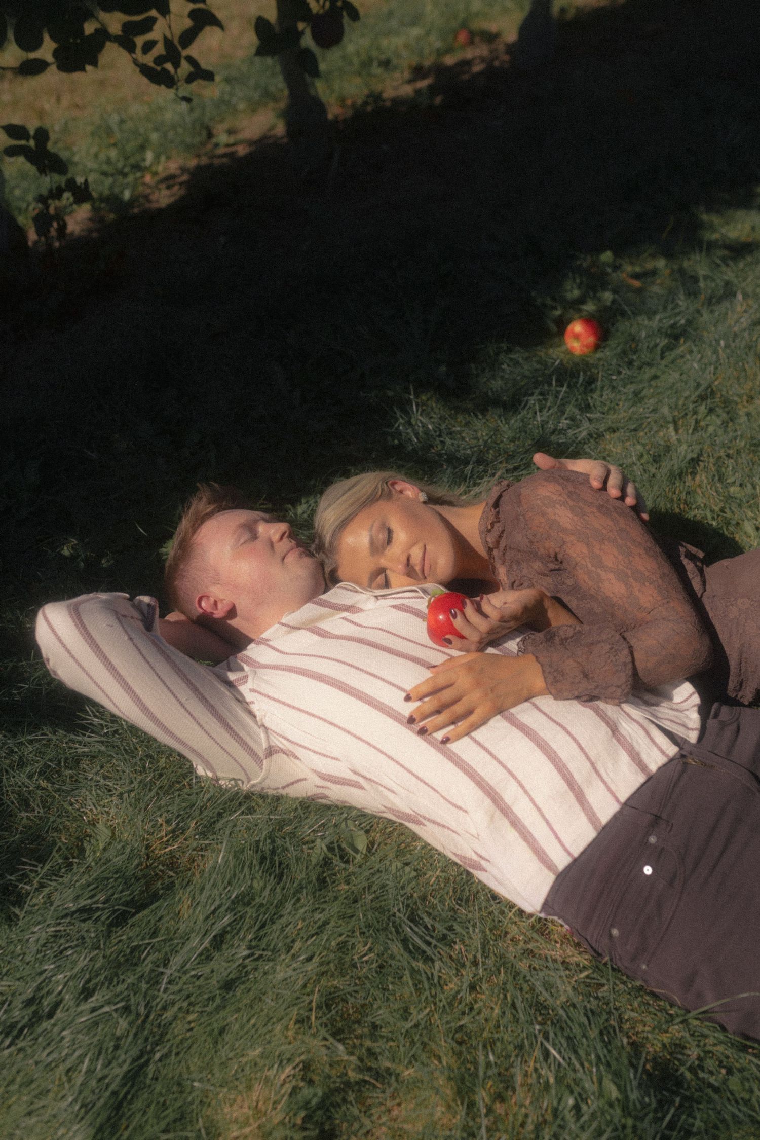 Friends relaxing on grass during a sunny afternoon.