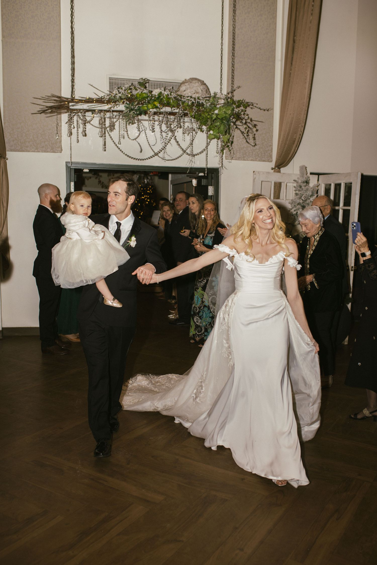 Wedding celebration with dancing couples on a dark wooden dance floor.