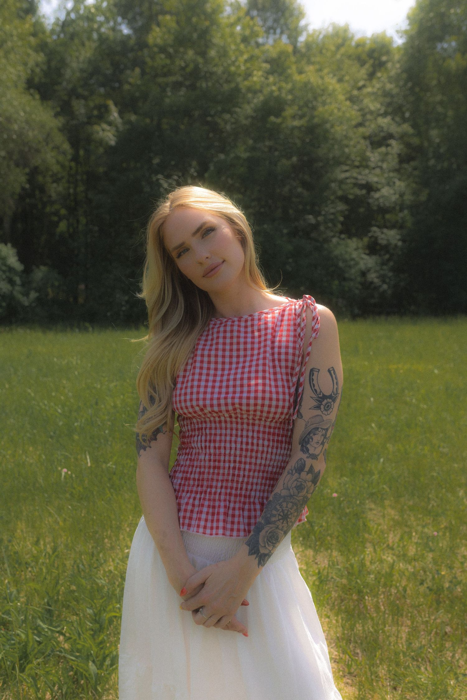 A series of artistic poses with a white prop in tall grass during golden hour.