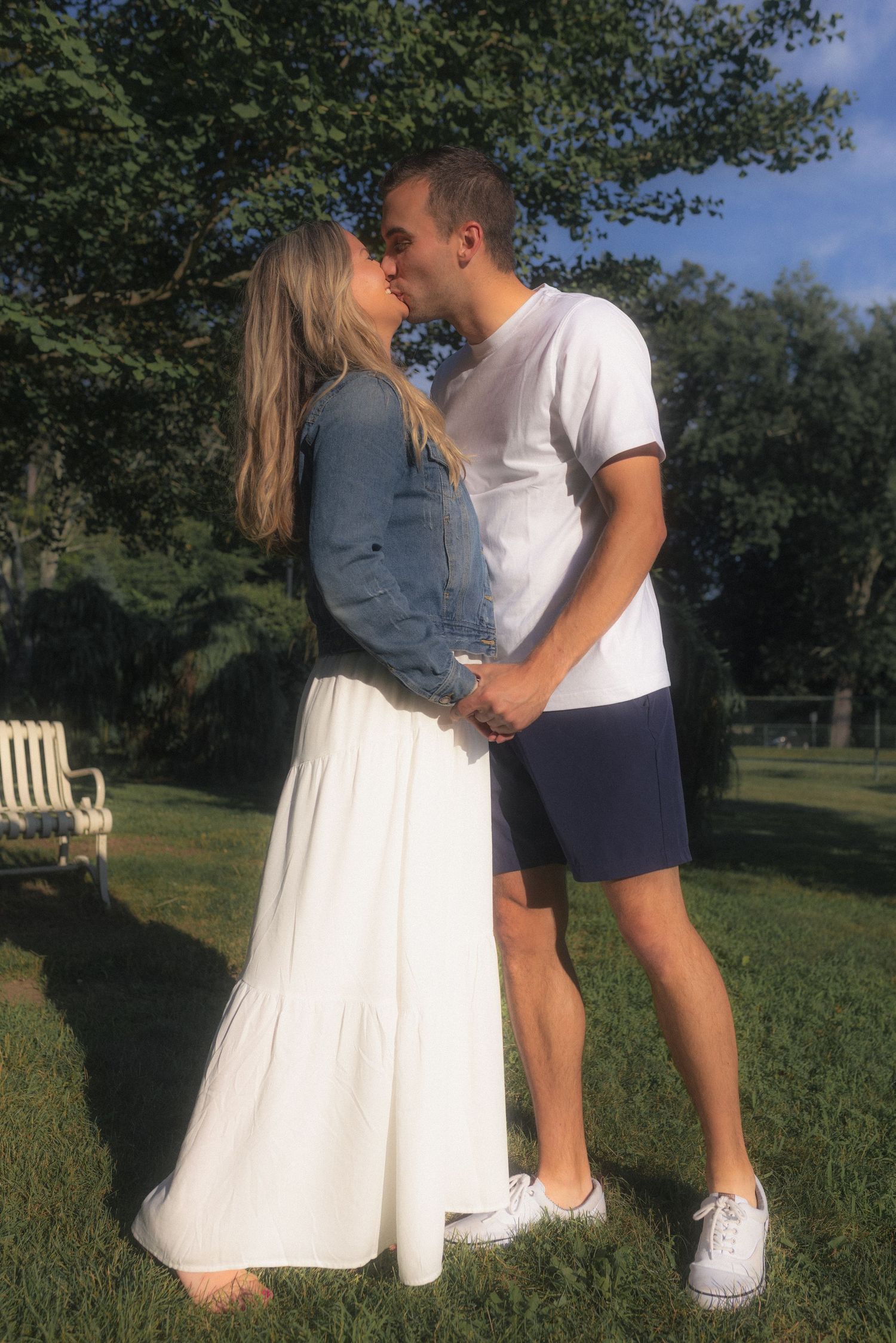 A couple sharing a dance moment outdoors on a sunny afternoon in a park.