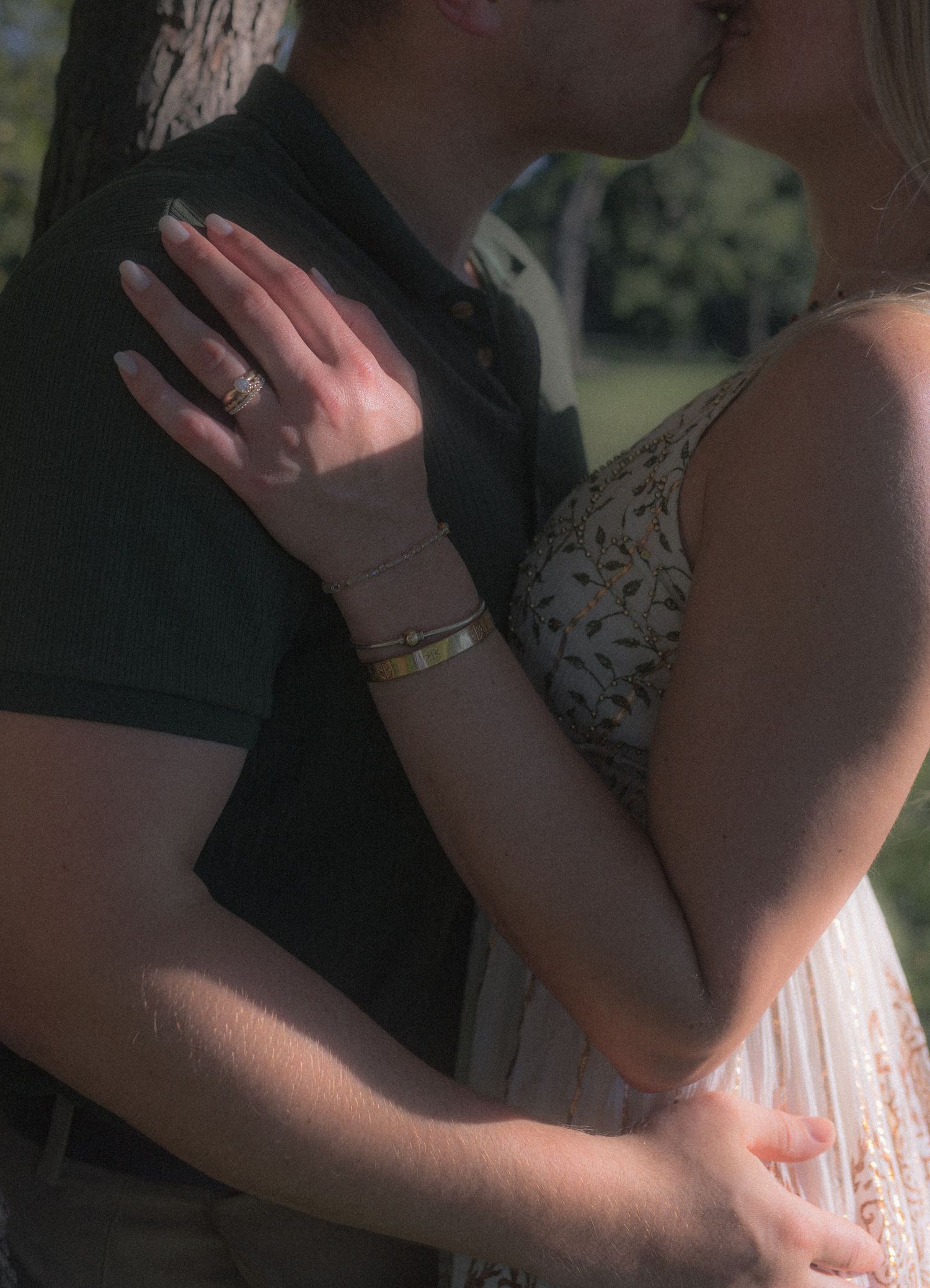 Close-up shot of a couple sharing an intimate moment outdoors.