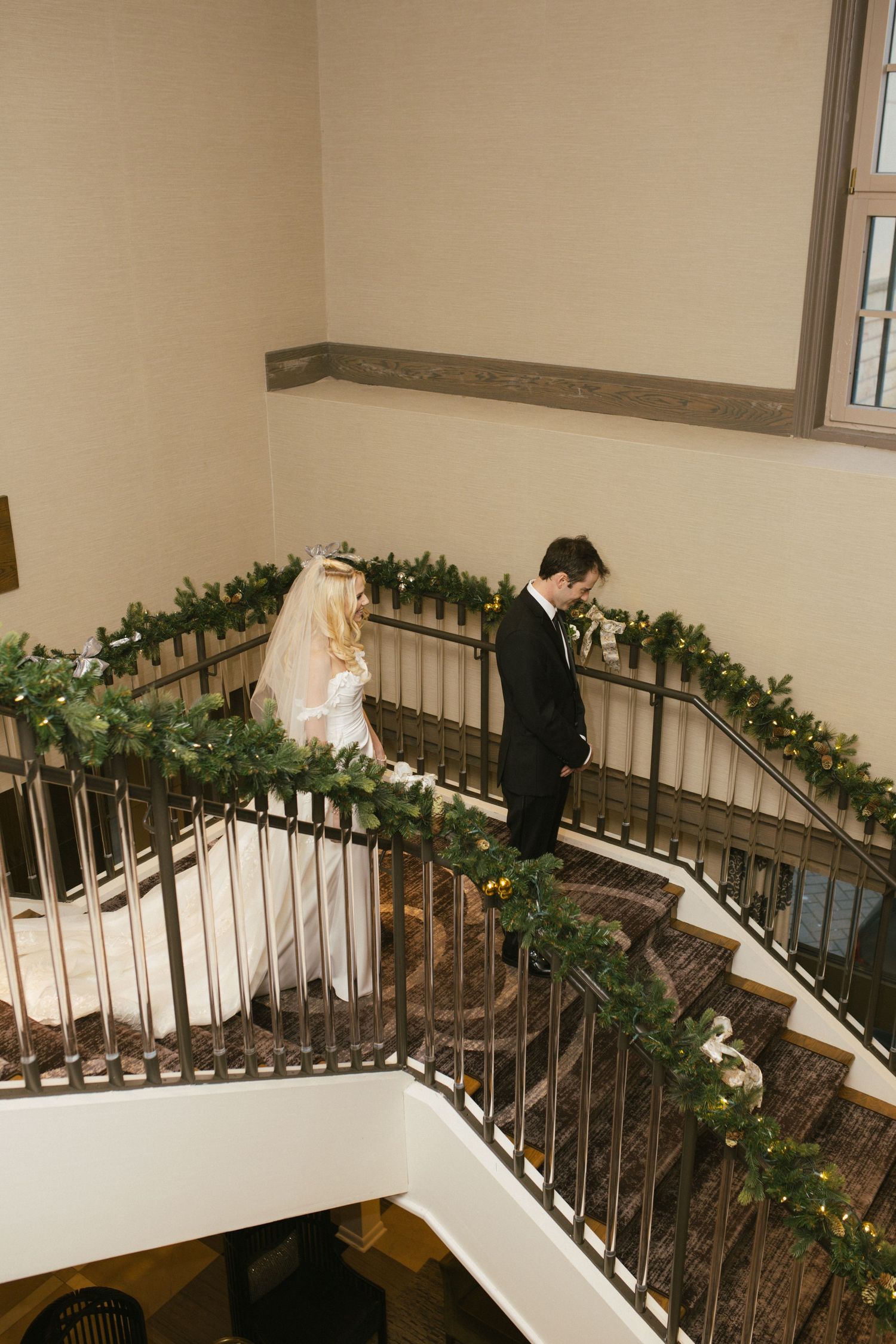 Elegant staircase decorated with greenery and lights for a wedding ceremony.