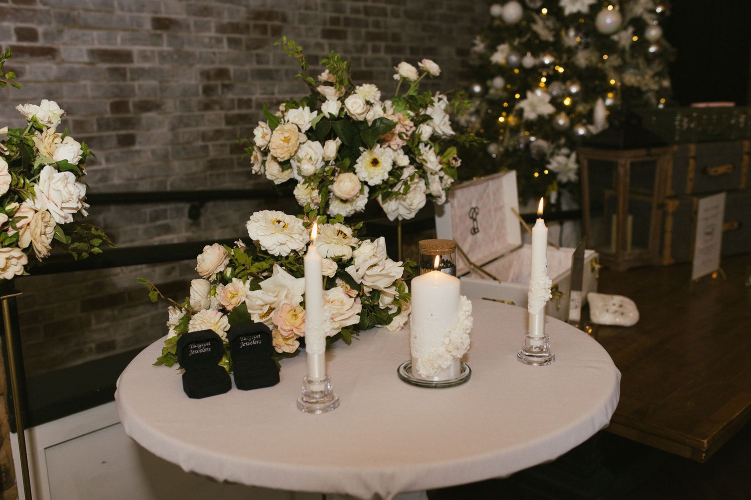 Elegant wedding reception table decorated with white floral arrangements and candles.