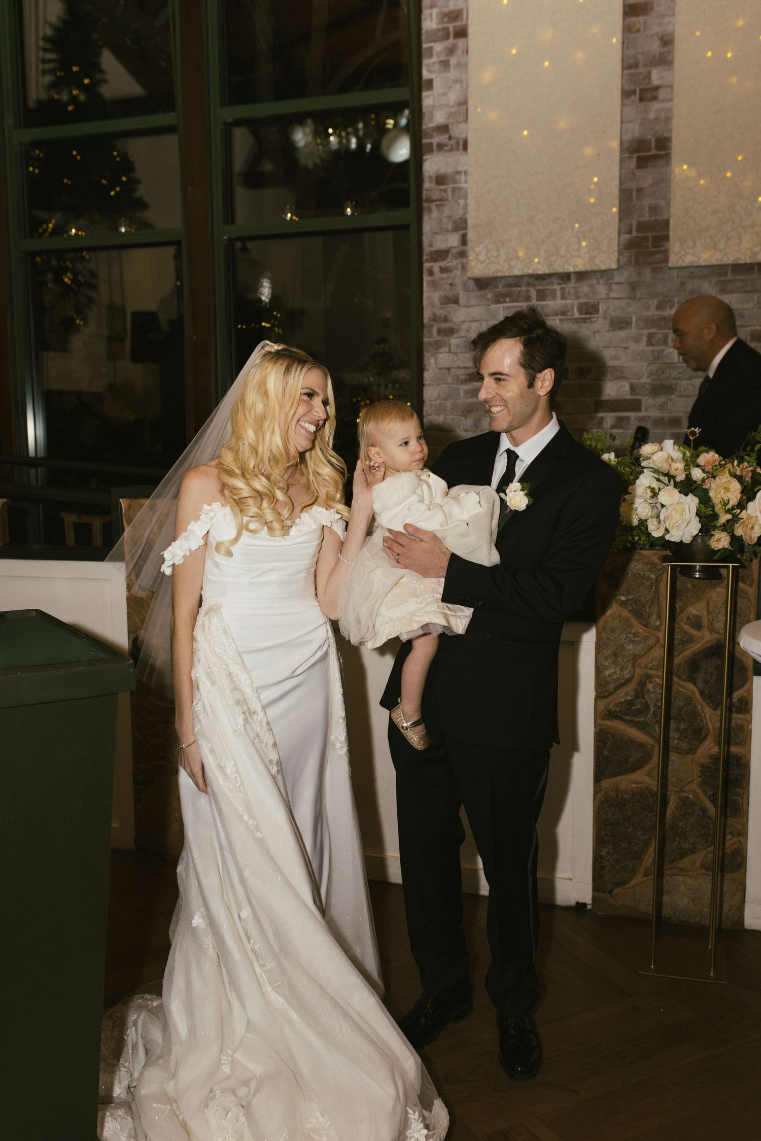 Wedding party celebrating in an industrial-style venue with exposed brick walls.