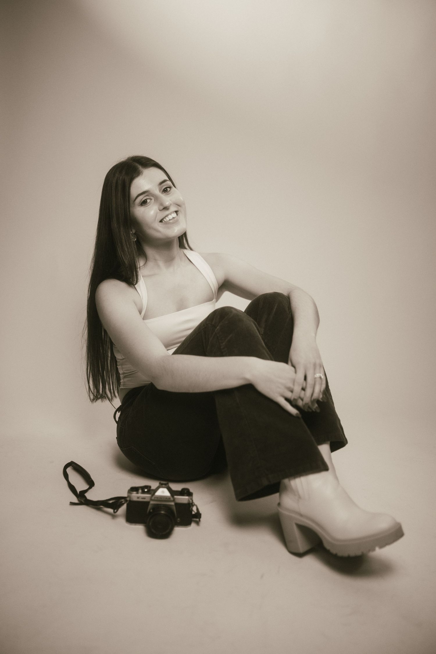 Artistic black and white portrait series showing relaxed poses against white backdrop.
