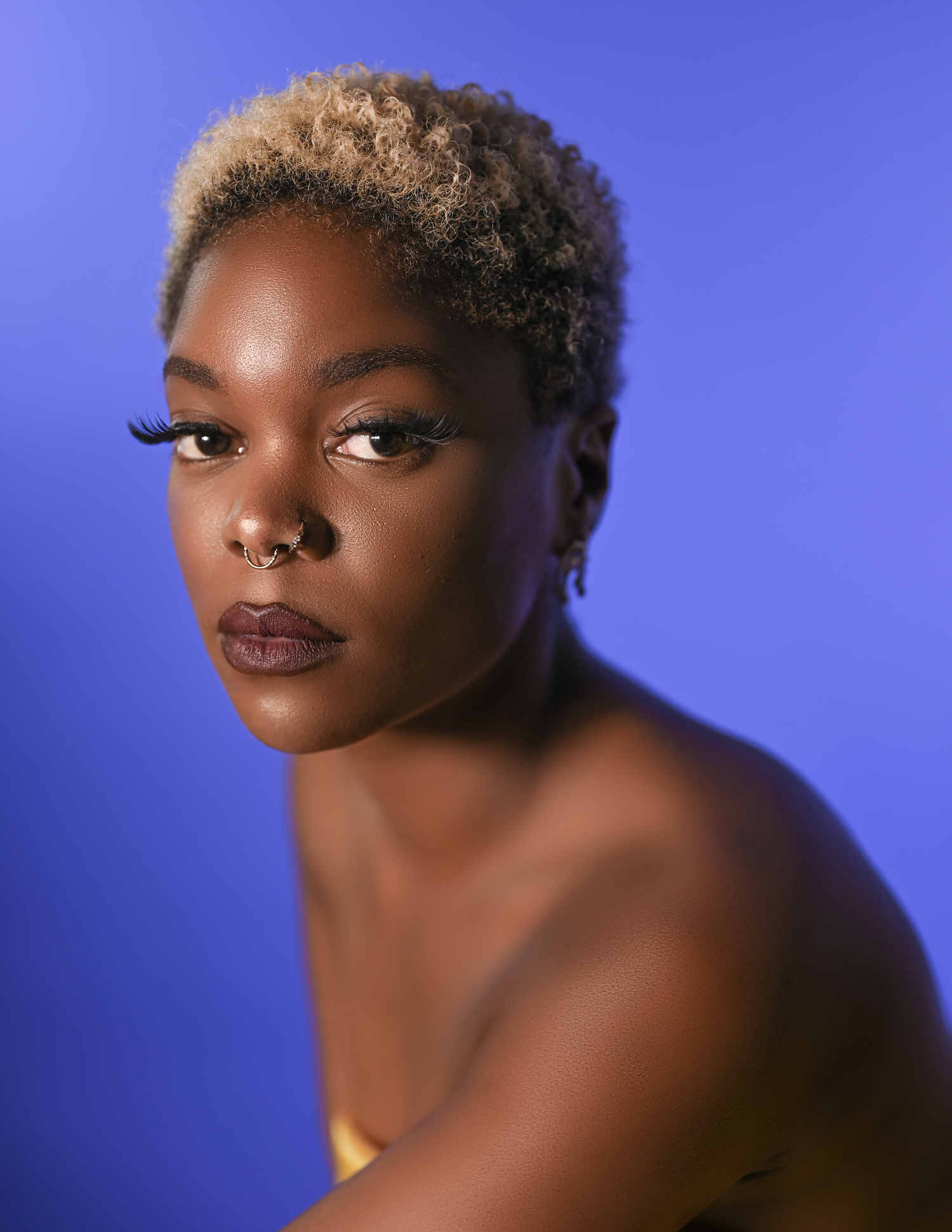 Artistic beauty portrait with natural makeup against blue backdrop.