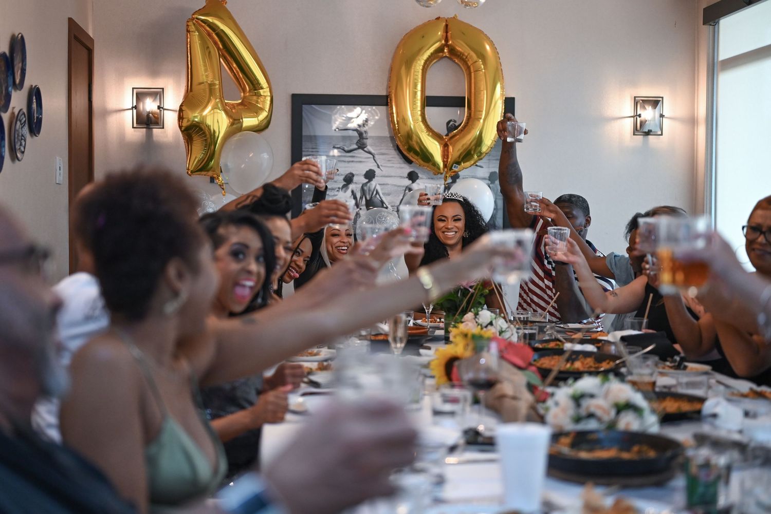 Elegant dining room setup with gold number balloons and wall sconces for special occasion.