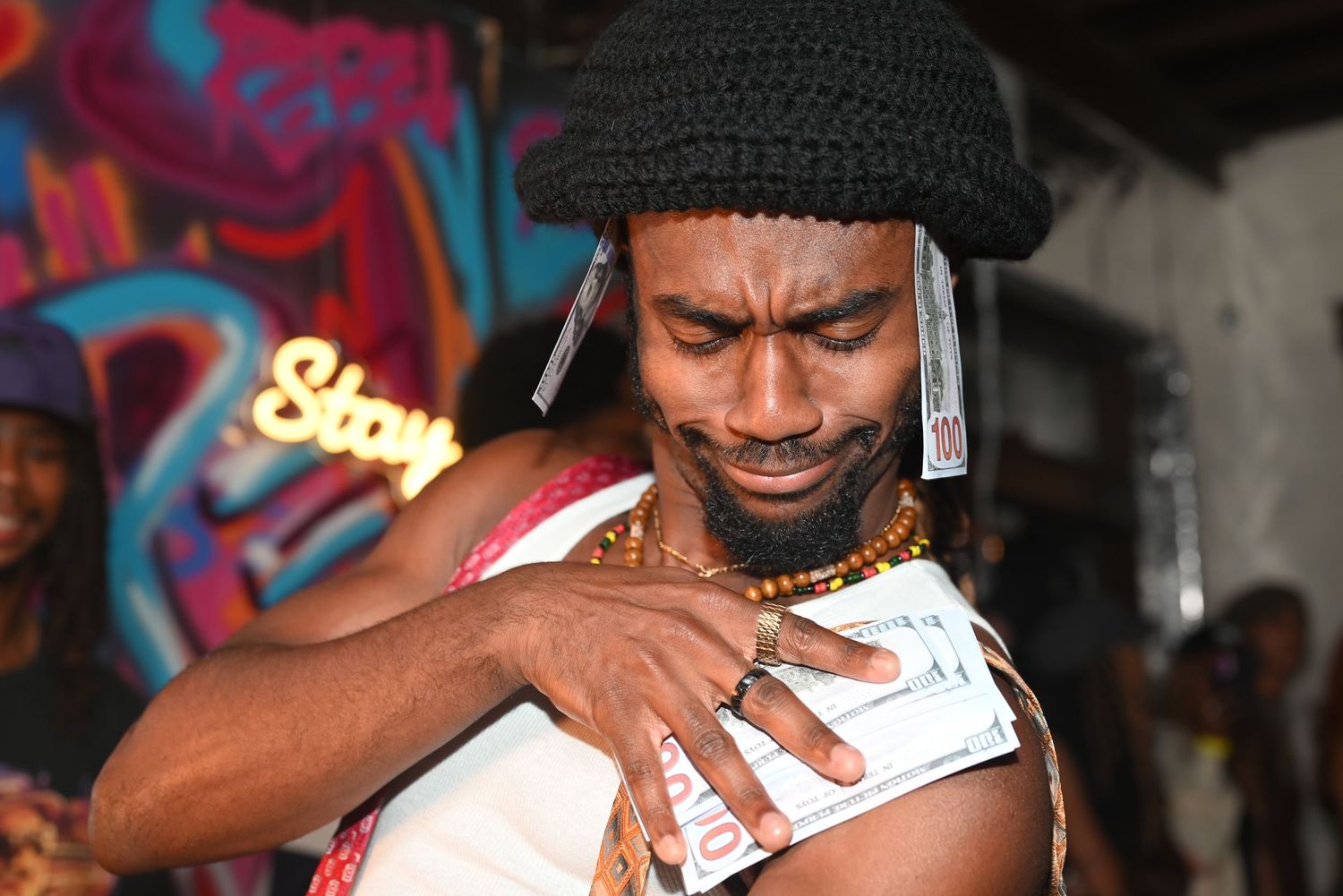 Performers dance and interact during a nightclub show with urban graffiti backdrop.