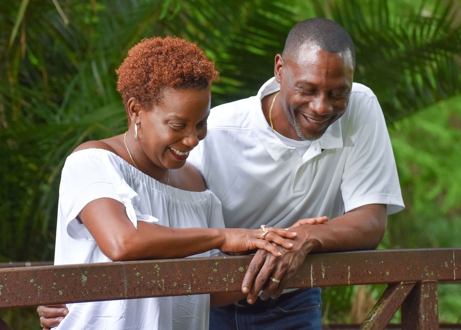Couple sitting on a wooden bench sharing an intimate moment outdoors.