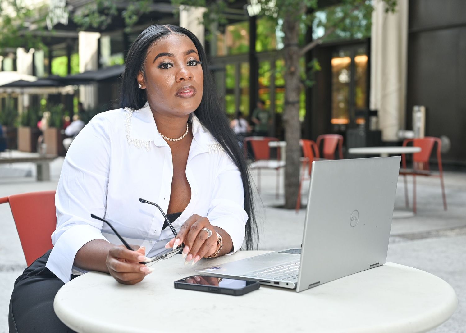 Professional working at outdoor cafe with laptop and modern office setup.