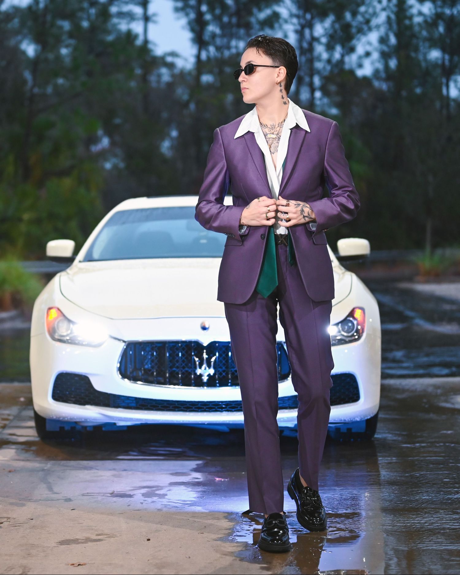 Purple suit styled with white luxury sports car in outdoor photoshoot.