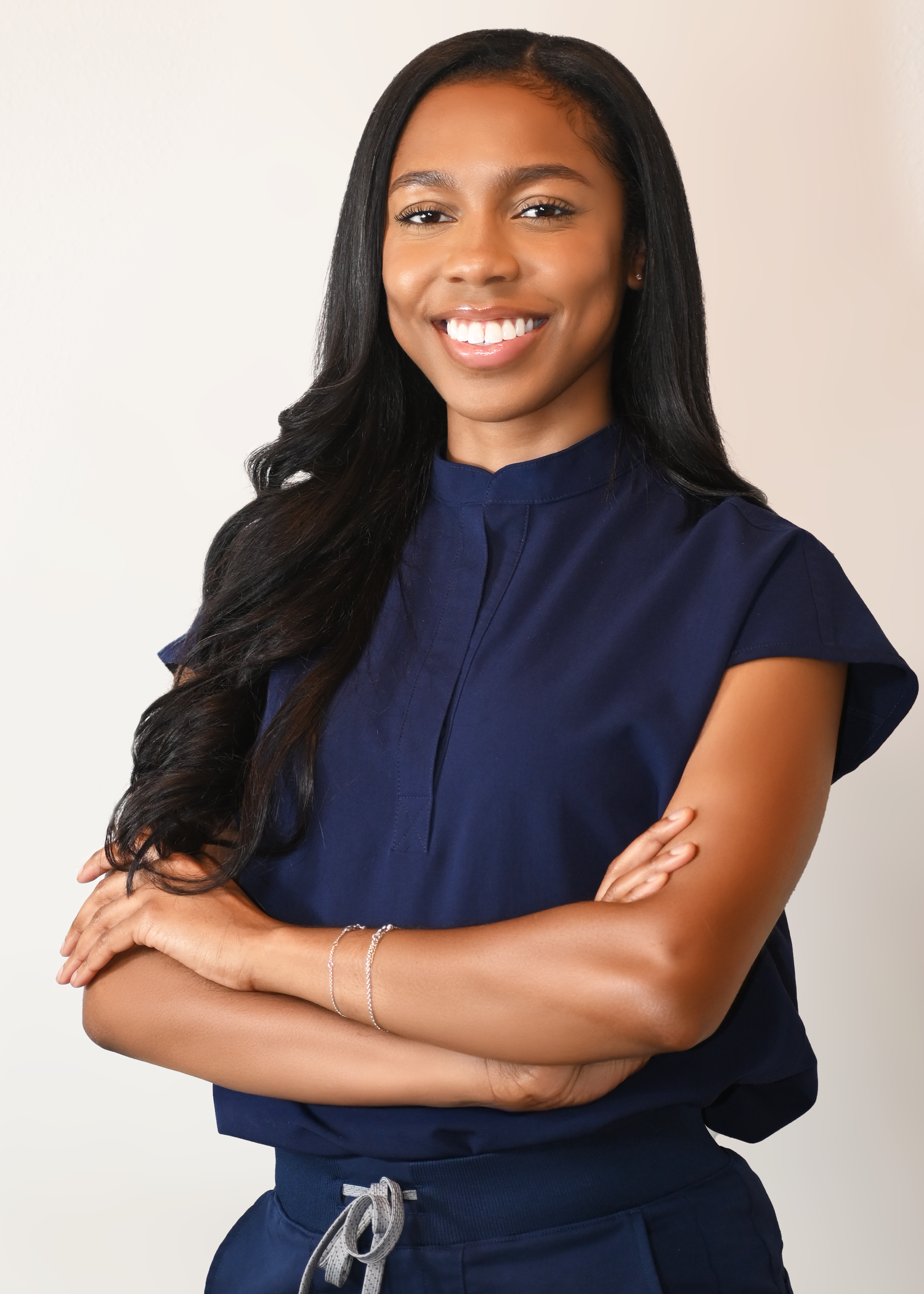 Confident pose in a navy blue outfit against a white backdrop.