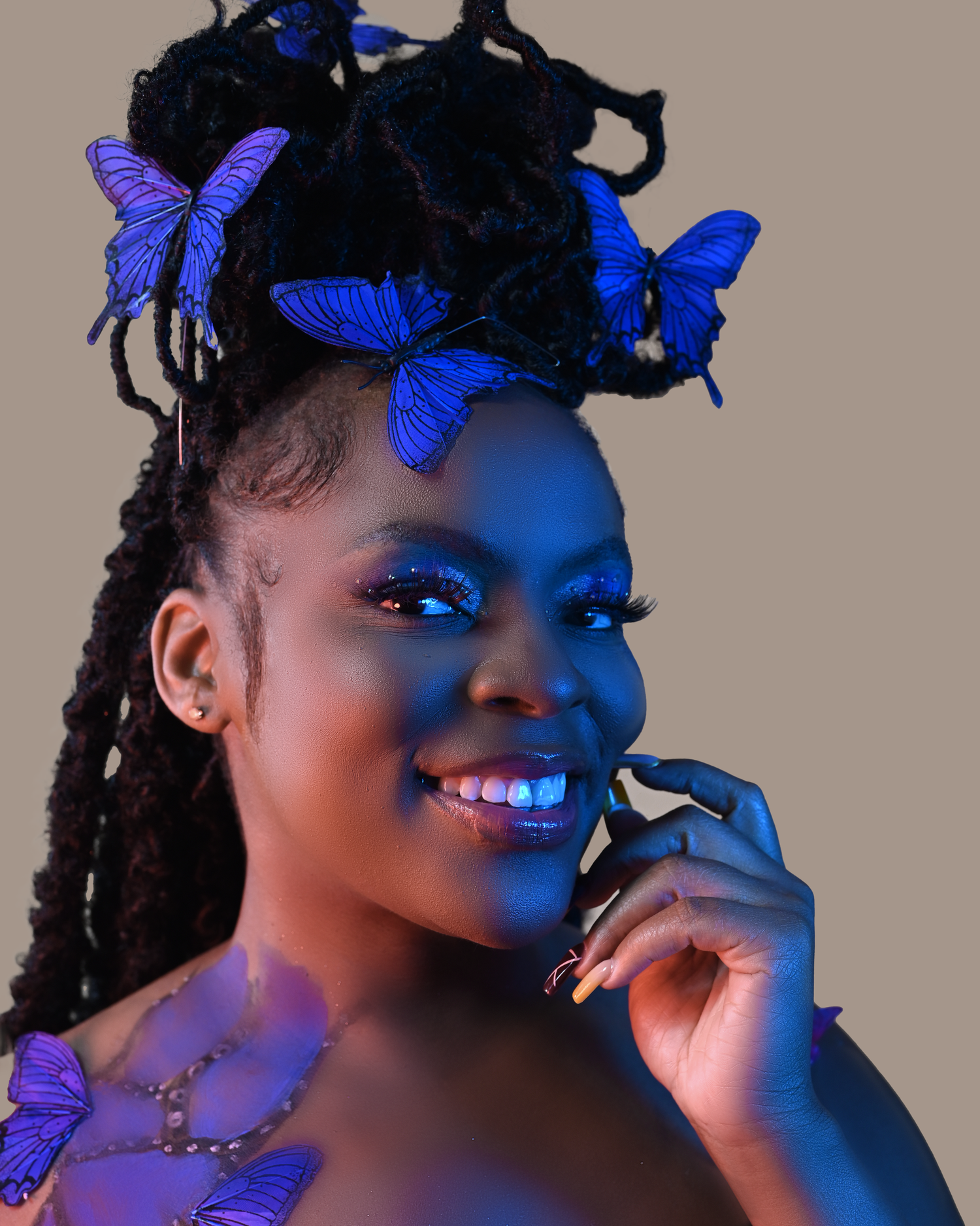 Ethereal portrait with blue butterflies and dramatic side lighting.