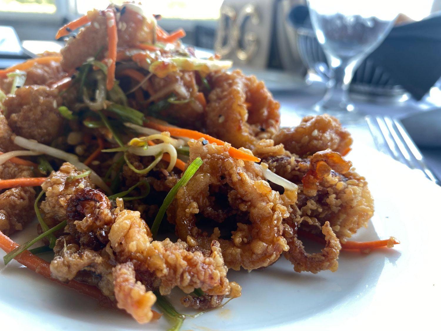 Crispy fried shrimp tossed in Asian-style sauce garnished with scallions and carrots.