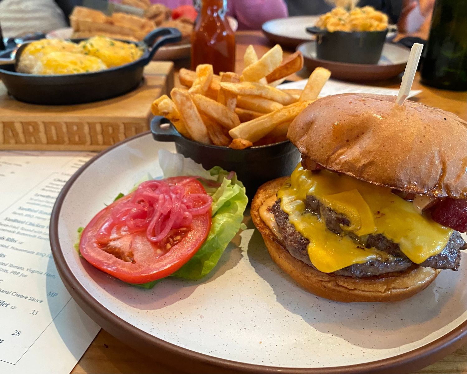 Classic cheeseburgers with fresh tomato and lettuce on toasted buns.